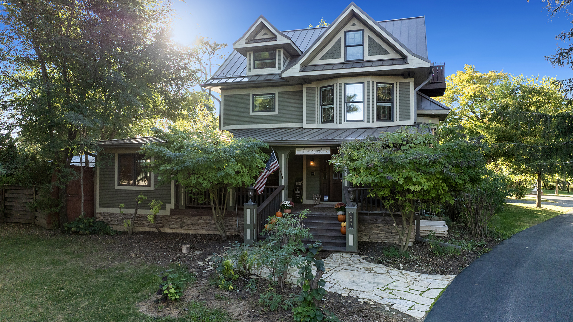 Welcome to a truly rare property - a gorgeous fully renovated 1913 residence paired with two additional custom-built homes, creating a multi-building estate with limitless potential. Thoughtfully restored and professionally updated inside and out, the main house spans over 10,000 square feet across four beautifully finished levels and offers six bedrooms, a library office, generous living spaces, and modern systems throughout - including separate HVAC for each floor. Special care was taken during the meticulous renovation to preserve the elements of timeless character while integrating modern comfort, creating a home that remains both historic and elevated. The main level opens to a gracious foyer, original oak floors, large living and dining rooms, a dining porch, and a beautifully reimagined kitchen with quartz countertops, Wolf stove, and Subzero refrigerator. The dining porch opens to the magical stone fireplace and garden pagoda, a greenhouse-inspired structure built from historic barnwood and featuring moveable, removable sliding translucent walls and doors. Upstairs, the second floor features original wood floors and private en-suite bedrooms, including a master suite with a gas fireplace and a marble-lined, spa-inspired bathroom with a clawfoot tub and shower. This floor also houses a laundry room with two washers and dryers, a sink, and storage space. The third floor offers Hickory floors, two bedrooms, living room with gas fireplace, and bathroom with a custom Kohler double-vanity sink and marble-and-stone walk-in shower. Each bedroom includes its own vanity, and the master suite features French doors opening to a perfect small deck for watching sunrises or sunsets. The lower level, the stone cellar, is a distinctive space with bathroom, shower, custom-built Finlandia sauna, bedroom, studio kitchen, living room, workout and massage room, storage, storm shelter, and escape window. The 2,300-square-foot carriage house is its own private retreat with full kitchen, quartz countertops, living area, laundry, powder room, king suite with spa bath, and French doors leading to expansive private deck - ideal for guests, family, a creative studio, or a private office. Heated five-car garage parking sits below. Across the main drive is the exquisite 3,200-square-foot cottage. This light-filled, vaulted-ceiling home features an open-design kitchen with quartz countertops and a dining area, as well as full-length front and back decks. The second floor includes a large primary king bedroom with a catwalk leading to an open-air office and sitting room. The lower level comprises garden-style windows for light and emergency exits, custom-built room-length desk, living room, laundry, marble-tiled bathroom with shower, bedroom, concrete storage and storm shelter. The grounds are an enchanted, private sanctuary featuring a small greenhouse, water garden with koi pond and waterfall, flowing creek, yoga lawn, fruit trees, and native and herb garden. The property is offered largely furnished and is move-in ready, making an effortless transition as a turnkey residence, second home, hospitality hybrid business, multi-generational living, or divided lots. Discover countless cozy spots inside and out to rest and renew in this friendly, beautiful, quiet Midwestern community in the Rock River Valley; a one-of-a-kind offering.