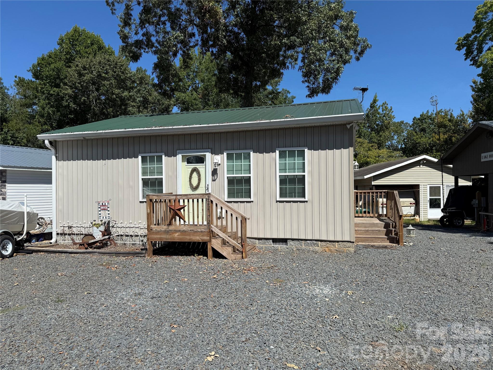 Welcome to 222 Lake Tillery Tr.  This is the Complete Package!!  Staring with the beautiful addition, you enter into an open concept living room, kitchen and kitchen island. Plenty of space to enjoy company and TV time. There is an electric range, a dishwasher, washer dryer and full size house bathroom. The 2008 Forrest River Flagstaff 34' Camper has been converted to all sleeping.  Queen in primary, 4 bunks in bunk room and an additional queen for extra sleeping. The HVAC is run to the camper as well as the addition.  Propane H20 on demand. This unit was complete in 2021. This unit also includes a 2001 EzGo Gas Golf cart and a 1996 Sunbird 17' with a radio, depth finder and fish finder. Mercury 90 HP 4 stroke. Come and see if this is your "Happy Place" in the community. Some furnishings to remain.  Nice building that will accommodate the golf cart. All buyers must be with a realtor to gain entry to the community.