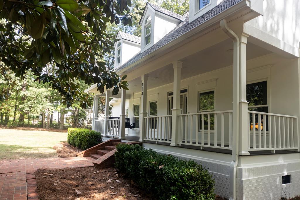 Exquisite 5-Bedroom Home with Modern European Flair and Stunning Views!  Located at the back of a quiet cul-de-sac in one of the most sought-after neighborhoods, this beautifully updated 5-bedroom, 3.5-bathroom home (plus a 1/1 detached garage apartment!) offers the perfect balance of modern elegance, exceptional functionality, and serene surroundings. Set on a spacious, wooded 1.14-acre lot, this property not only boasts a luxurious interior but also provides an ideal location with Brookwood School less than 4 minutes away. Gourmet Kitchen & Living Areas: Step into the heart of the home, where a Modern European kitchen steals the show. Featuring top-of-the-line appliances including full-sized Subzero fridge/freezer, Wolf steam and convection wall ovens, Wolf gas range with griddle, Bosch convection oven/microwave combo, and Cove dishwasher, this kitchen is every chef's dream! Pecky cypress beams and painted tongue-and-groove details enhance the space with rich textures, while quartz countertops and a stunning 9x5 cascading quartz island provide plenty of prep space. Two oversized 4x6 windows bring in plenty of natural light and capture the beautiful views of the surrounding landscape. The living room, with its soaring vaulted tongue & groove ceiling, is equally impressive offering a cozy ambiance with a wood-burning fireplace (gas starter), perfect for evenings at home. Built-in bookshelves provide elegant storage, enhancing both form and function. The home has been meticulously updated with modern interior lighting, fixtures, switches, and fans throughout. Bonus Room & Master Suite:  Enjoy an additional spacious 1/1 apartment (460 sqft) above the detached garage. This versatile space is finished with real wood plank paneling and includes a fully renovated bathroom and LVP flooring ideal as a guest suite, media room, home office, or exercise room. The master suite is a sanctuary, with a separate sitting room or office area, built-in bookshelves, and a beautifully appointed bathroom that boasts a custom-built floating vanity, free standing tub for two, oversized walk in shower with rain can, and closet with custom built-in drawers & shelving. Outdoor Living & Grounds: Step outside to the newly updated back deck with cables that wraps around the living area, offering a seamless transition to the lush, private backyard. Enjoy outdoor living with front and back porches, a stream running at the back of the property, and easy access to the pool and clubhouse just up the street!  Extra Features & Amenities: This home includes a whole house water softener system, reverse osmosis drinking water system, and encapsulation with dehumidifier to ensure comfort and quality. The climate-controlled storage in the garage features wall-mounted bike racks and custom cabinetry, while the outbuilding provides ample space for all your lawn equipment and power tools. Special Updates: A new roof (2018), exterior paint, new carpet in upstairs bedrooms, and new shed ensure that this home is as functional as it is beautiful. The bar area has been updated with a sleek quartz countertop and new cabinet doors making it perfect for entertaining. This stunning home truly combines luxury, practicality, and beauty. With its meticulously maintained interiors, exceptional location, and breathtaking surroundings, it is sure to be the perfect retreat for its next owners!  Sellers are licensed Realtors in the state of GA #369599 & #391145