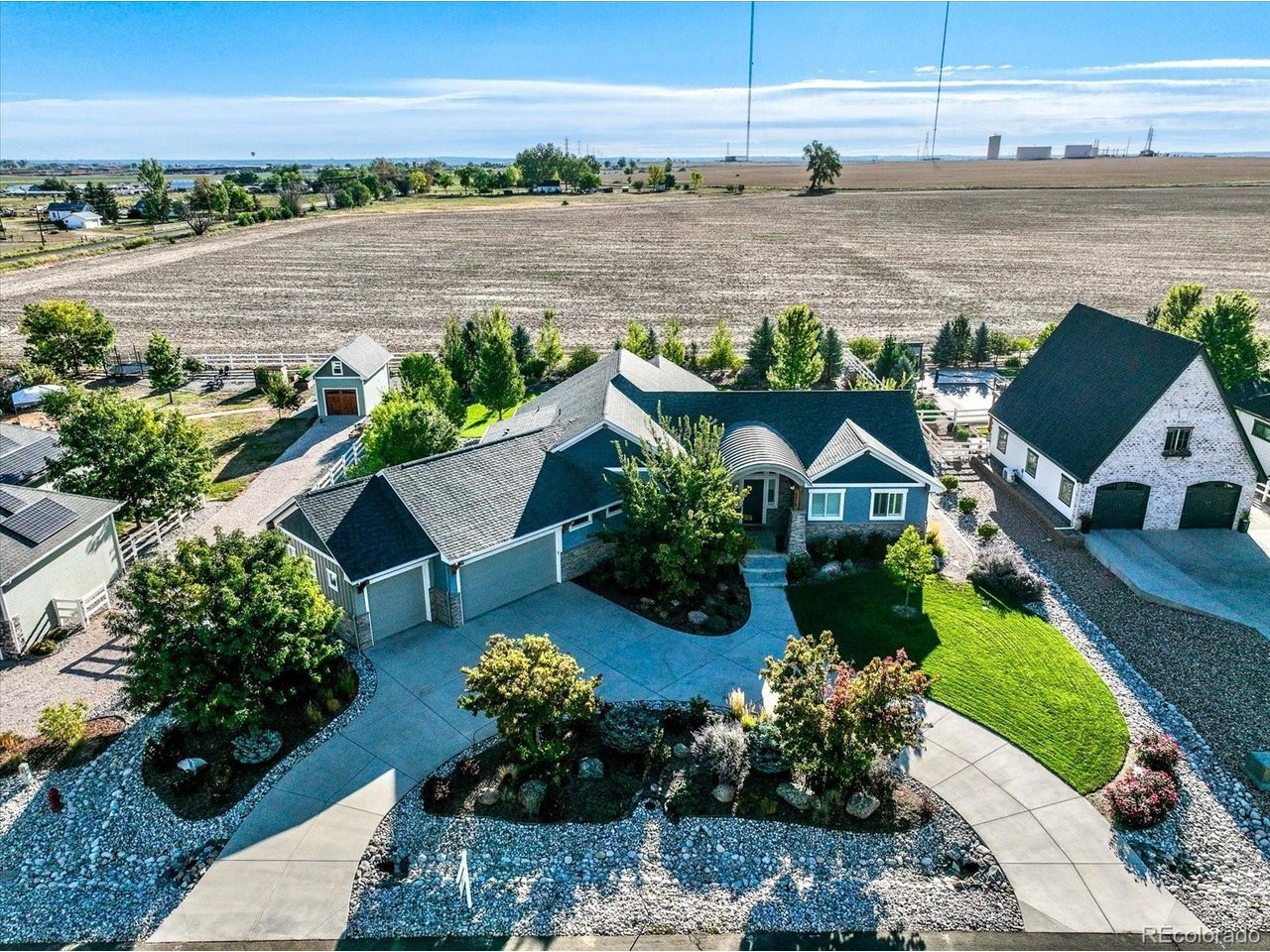 Welcome to 6916 Peace Street, where custom design, open-space views and exceptional indoor-outdoor living come together. On over half an acre, this custom-built Angel View Estates home offers 4 bedrooms, 4 bathrooms and more than 5,800 square feet. Built in 2017, the home was thoughtfully designed with a functional floor plan, extensive upgrades and exceptional spaces for entertaining. The showpiece of the property is the incredible outdoor living space. The custom covered patio and outdoor kitchen overlook peaceful open space and feature a Blaze propane grill, built-in ice coolers with direct-to-yard drains, outdoor TV, heater and built-in outdoor speakers. Whether hosting a crowd or enjoying a quiet Colorado evening, this backyard was designed to be used and enjoyed. Inside, the gourmet kitchen features an oversized island, farmhouse sink and Jenn Air appliances, wine refrigerator and walk-in pantry. The adjoining great room offers a gas fireplace, custom coffered ceiling and built-in shelving. The main level includes two bedrooms with a Jack & Jill bath and a spacious primary suite with two walk-in closets, separate vanities, soaking tub and oversized custom shower. The mudroom/laundry room offers washer and dryer (included), built-in drying rack, utility sink, generous storage with convenient access to the primary suite and garage. The finished lower level is bright and inviting, with an oversized egress window bringing in abundant natural light. It features a spacious entertainment area with custom display cases, bedroom, full bath and Control4 house audio system. A dedicated gym with matted rubber flooring, wall mirrors and Sunlighten sauna creates a complete workout and wellness space. Generous unfinished storage provides plenty of additional space for organization and seasonal items. With its custom design, oversized 3-car garage and standout outdoor living, this home truly sets itself apart!