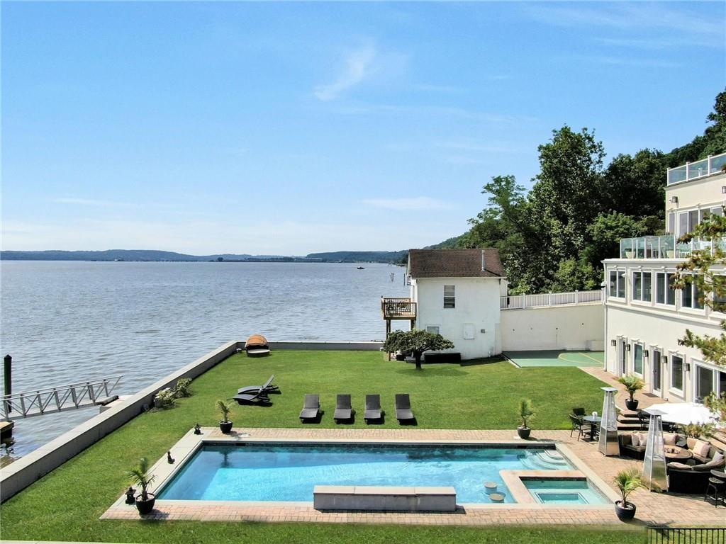 Inspirational! The Landing... The ultimate in luxury, waterfront living on the Hudson River and only 35 minutes to Manhattan! A 4,800sf home with a wall of glass facing the water from multiple levels and there's an elevator to all floors! This property offers it all: an inground pool with spa, a long dock with a rocky/sandy beach, and a freestanding 400sf studio building. Every system, window, door, flooring, wall, kitchen and baths have been dramatically replaced with a modern floorplan, with large open spaces laid out over 4 to 5 levels. And of course, all of the mechanicals are like new too. The Landing is a great weekend home or full-time residence. And it's turnkey! No aggravation or work to do! Originally built in 1860 as a Queen Anne Victorian, it was known as the Coles Mansion. The home maintains its original architectural design from its exterior on the road/west side but offers a totally reimagined interior and exterior on the east side (sunrise side) for 21st century waterfront living. In 1891 the home's entire rear property was rebuilt, leveled and built up as a beautiful flat lawn and garden. Its bulkhead design has been supported through the years and safely protects the home from mother nature's surprises. In about 2015, the current owners worked with their architect and designers to create a home for a modern lifestyle with luxurious finishes, and with multiple windows and glass doors, to see the Hudson River from almost every room. The home features numerous amenities, such as state-of-art kitchen, with a built-in seating alcove facing the river; multiple bar stool seating too from the long counter; double Sub-Zeros refrigerators, 6 burner Wolf cook top with griddle, Miele double ovens, coffee station and dishwashers. The second kitchen on entertainment level offers 2 Sub Zeros (1 full size wine fridge), induction cooktop, and Cabana area that functions as another kitchen and entertaining area outdoors and opens out to the pool and patio space in the rear yard. It also features a basketball area. The primary bath includes a steam shower and soaking tub. Onyx powder room. Marble floors with radiant heat throughout the first level. Stylish 8ft walnut wood doors with stainless steel inserts throughout gives a modern, midcentury vibe to the house. Stone counters, textured walls, and tray ceilings with recessed lighting. Other finishes include Venetian plaster, rice paper, stone and metal tile work, fireplace in living room and fire pits outdoors. Even the garage was modernized to accommodate 3 cars and offers 2 charging ports for electric cars. Its translucent glass doors provide an abundance of light at almost any time of day. The Landing is conveniently located between Piermont and Nyack, and its many shops, restaurants and marinas - only a nice walk away or very short drive. The Tarrytown train goes to Grand Central - only a 12-minute drive, and the bus to Midtown stops in front of the house! Nothing Compares to The Landing!