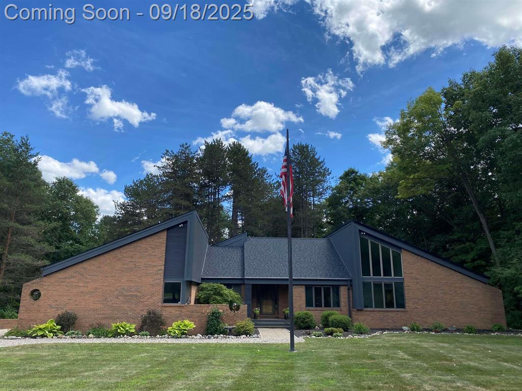 Welcome to 5220 Nardoni Lane in Dryden! This one-of-a-kind custom-built Mid-Century Modern retreat sits on 10+ serene acres and blends timeless design with modern updates. Featuring 25' vaulted ceilings and walls of windows, this home is filled with natural light and sweeping views of the property.  The spacious layout offers 3 bedrooms with an optional 4th downstairs, a dedicated home office, and a luxurious primary suite complete with a remodeled bath and doorwall access to the expansive deck. With 2.5 baths, abundant storage, and multiple living spaces, this home is designed for both comfort and function.  Step outside to your private paradise, where you'll find a lake with a dock, a pole barn, 5-car garage, and a sprawling deck with a hot tub-perfect for relaxing or entertaining.  This property combines striking architecture with peaceful country living, all within reach of town conveniences. Don't miss the opportunity to own this extraordinary home.