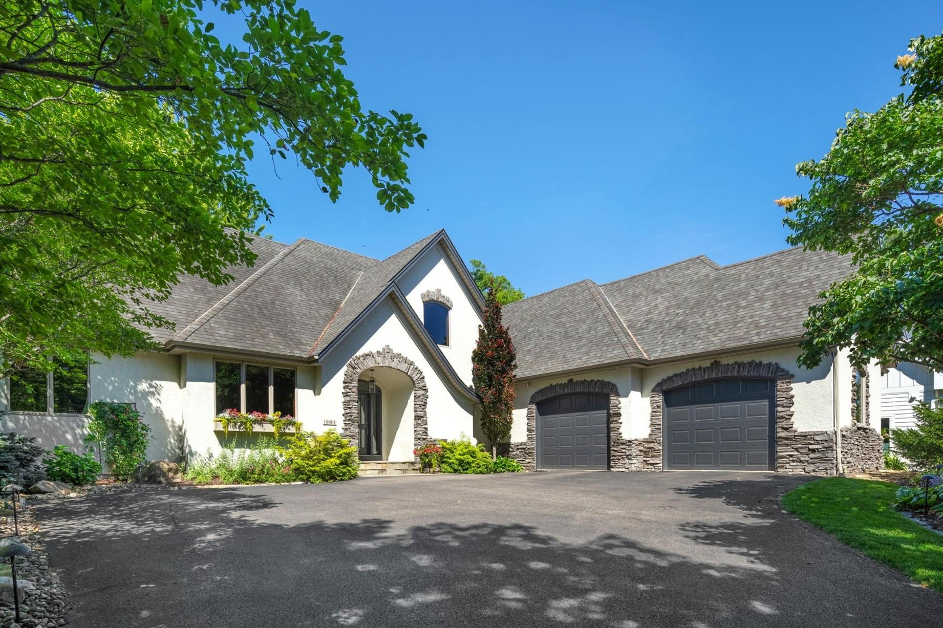Enjoy lakefront living at its finest on the quiet bay of Lake Marion. Set on a beautifully wooded 0.7-acre lot in a peaceful no-outlet neighborhood, this property offers an exceptional combination of privacy, quality updates, and waterfront living, all within the Lakeville South High School boundary.The main level was extensively renovated in 2020 and features warm, timeless finishes throughout. Hardwood floors, 9-ft ceilings, built-in speaker systems throughout, and large windows create inviting living spaces filled with natural light and beautiful views of the lake.The kitchen is meticulously curated, featuring high-end appliances, a large center island, custom cabinetry, and a walk-in pantry. Enjoy informal and formal dining spaces, a main-level private office, and screened porch.The main-level primary suite stuns with lake views, walkout access to the screened porch, a spacious walk-in closet, and a beautiful full bath.Four additional bedrooms provide plenty of space for residents and guests, with two bedrooms and an updated full bathroom (2020) upstairs, plus two more bedrooms and nearby bathroom on the lower level.The finished lower level adds even more room to spread out and entertain, complete with a family room, wet bar, recreation area, and exercise room.Outside, the setting is simply hard to beat. Deck, expansive patio, shoreline firepit, private dock with boat lift, and peaceful water feature create multiple places to relax and enjoy the surroundings.Located on a peaceful bay with limited water traffic, the property offers easy access to boating, fishing, kayaking, and paddleboarding while maintaining a quiet, peaceful atmosphere.An oversized four-car garage with a dedicated Rheem furnace and more than 1,100 sqft provides plenty of room for vehicles, storage, and all the fun gear that comes with lake living.