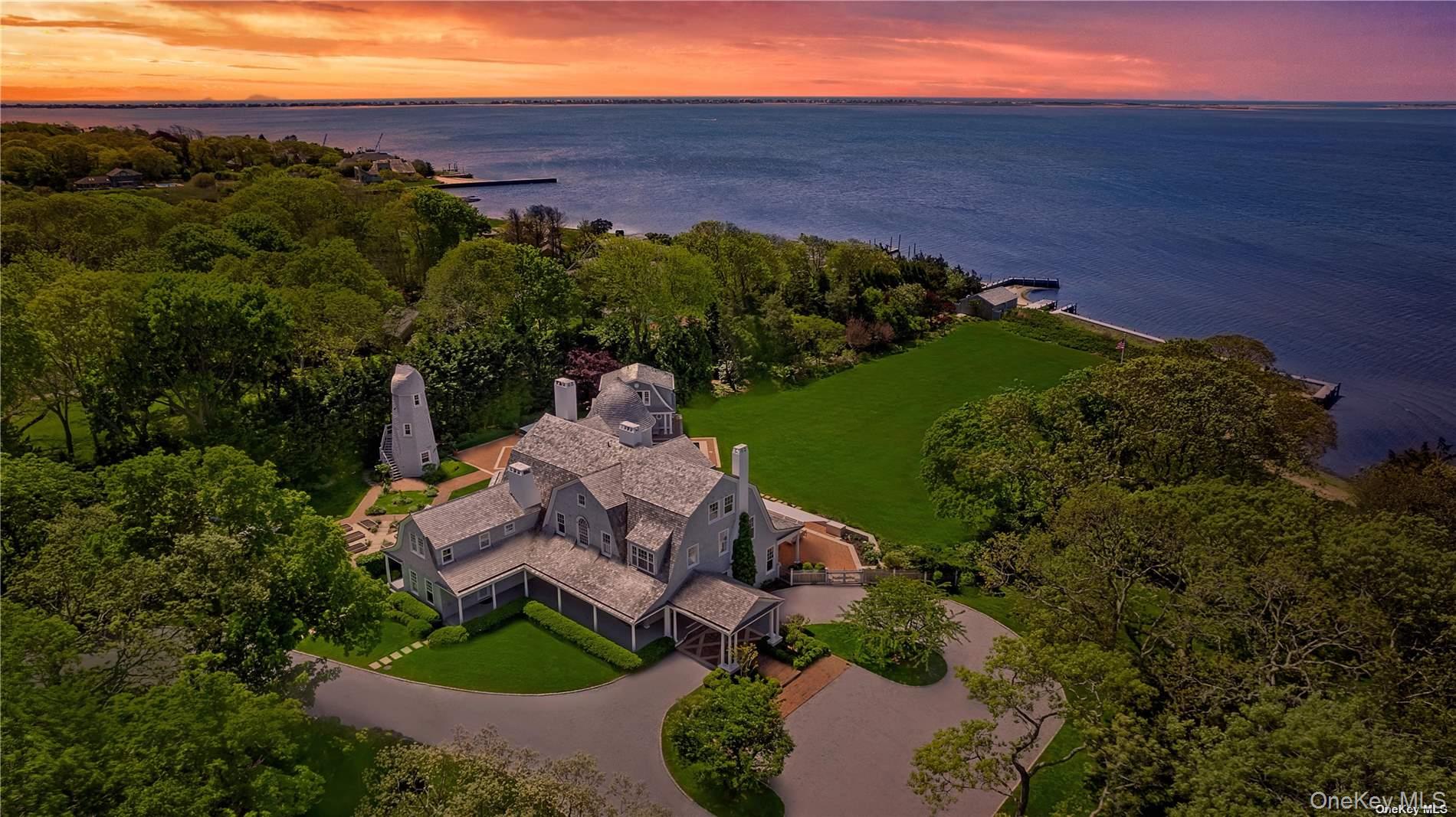 This majestic, one-of-a-kind estate is set on 4+ private, resort-like acres south of Montauk Highway. Its unique location on the southwest-facing waterfront provides incredible sunset views over Seatuck Cove and Moriches Bay from large windows throughout the bright, airy main residence. Perfect for entertaining, the meticulously updated 9-bedroom, 9.5-bath main home features a chef's kitchen with granite countertops, Wolf stove, dual ovens and dishwashers, and a 17-foot island. There's a living room with a built-in bar and wood-burning fireplace, a dining room, family room, handsome library and sunroom with wood-burning fireplaces, and a temperature-controlled wine cellar; and French doors lead to an ample patio overlooking the water. The primary bedroom has dual closets, custom built-ins, a bathroom with radiant floor and dual vanities, and a porch with sweeping water views. A former 19th century hunting lodge, the home blends old world charm with modern-day amenities, including an elevator and state-of-the-art mechanical systems, and features a porte cochere for shelter when getting in and out of vehicles. The sprawling property, which is bordered by tall perimeter trees and accessed through a gated entrance, includes a four-bedroom guest house with full kitchen; a detached five-car garage with commercial-grade hydraulic car lifts; a charming, refurbished, old-fashioned windmill; and a pool house with sauna, and gym overlooking the 45x20 heated saltwater gunite pool. A sweeping, lush lawn extends down to 234 feet of waterfront, where there are docks, a sandy beach and a boathouse. Har-tru tennis courts complete the country club experience. There's little reason to ever leave!, Additional information: Appearance:like new,ExterioFeatures:Tennis,Interior Features:Guest Quarters,Lr/Dr