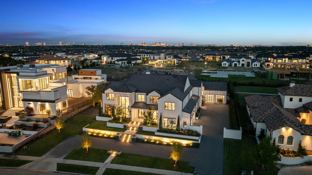 Located in the prestigious Hills of Kingswood, this completely custom-built home by Alford Homes is a seamless fusion of modern luxury and functional design, set on nearly an acre of resort-style grounds. Inside, vaulted ceilings with exposed beams, a statement fireplace, and hardwood flooring create a breathtaking first impression. The sleek open-concept kitchen is a showstopper, featuring a marble waterfall island, sub-zero refrigerator and freezer, a built-in Miele plumbed coffee system, dual dishwashers, gas range, and a striking chandelier. The adjacent walk-in pantry is equipped as a full prep kitchen—ideal for staffed entertaining. A wall of motorized glass pocket doors open to the outdoor living space, effortlessly extending the interior footprint. For year-round enjoyment, motorized screens lower to create a comfortable, shaded retreat free from unwanted pests. The nearly one-acre lot includes a sparkling pool and spa, an in-ground trampoline, basketball court, and a sunken fire-pit lounge that creates an unforgettable setting for entertaining. The covered patio offers room to dine, unwind, and take in the beautifully landscaped surroundings. The main-floor primary suite is tucked away for ultimate privacy, while the ensuite bath feels like a personal spa with dual vanities, a soaking tub, and an oversized walk-in steam shower—alongside his and hers separate custom closets. This home also offers two laundry rooms—one upstairs and one down—as well as a private office, a spacious game room, and a versatile bonus room to accommodate a variety of lifestyle needs. Set behind the guarded gates of one of Frisco’s most elite communities, this residence offers privacy, prestige, and unparalleled access to upscale amenities. Enjoy being just minutes from The Star, Legacy West, and Frisco’s finest dining, shopping, and entertainment destinations—all while returning home to a quiet, secluded retreat that feels worlds away.