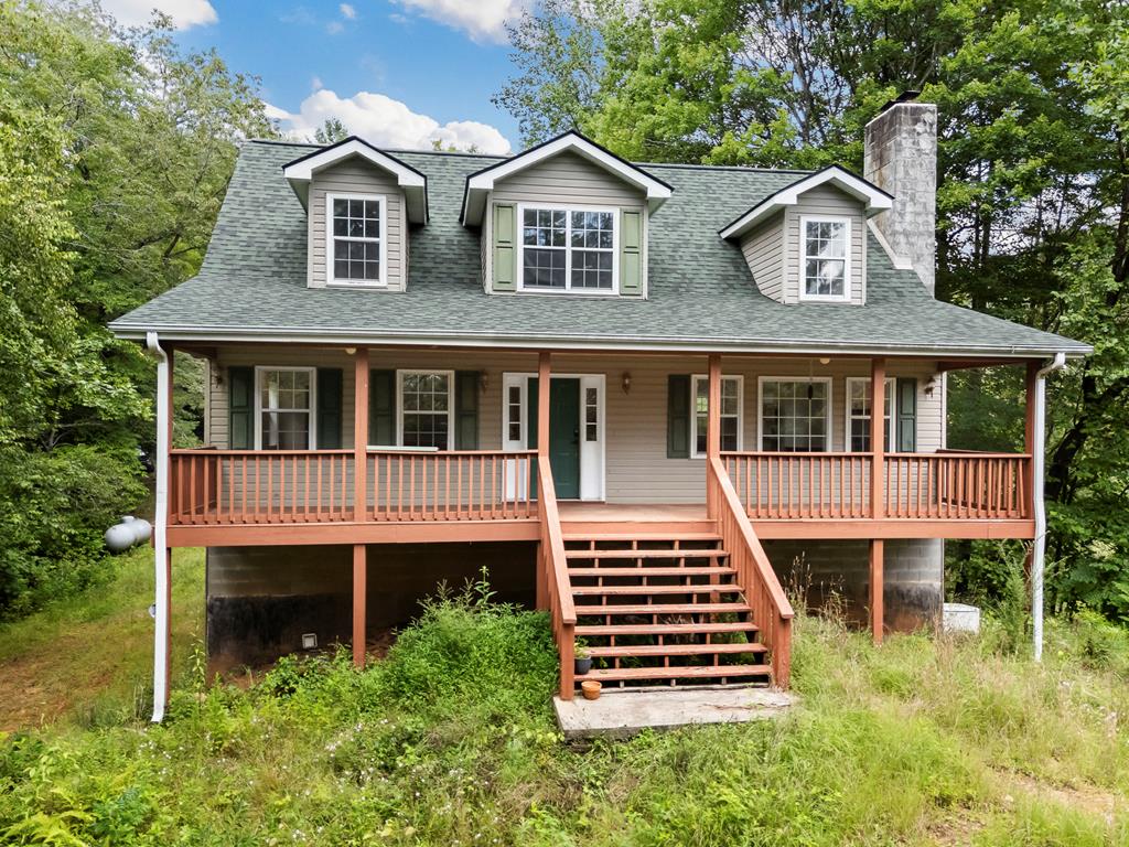 SHORT SALE! Hidden away on almost 15 unrestricted wooded acres, this secluded 3-bedroom, 3-bathroom home with full-length front and back porches offers peace, space, and potential. A winding driveway leads you through a canopy of trees to the private homesite with plenty of parking and room to roam. Ascend the stairs to the full-length front porch that welcomes you into this charming, bright home where wood floors run throughout, creating warmth and continuity. Step inside to the dining area, bathed in natural light from the bay window. The adjacent kitchen features stainless steel appliances, generous granite countertops, a central island, and a pantry for added storage. The spacious Great Room has lots of large windows, a whitewashed stone wood-burning fireplace, and vaulted ceilings that enhance the open, airy feel. Completing the main level is a large Master Suite with an ensuite bath offering double vanities, a step-up garden tub under a stained-glass window, and a sizable walk-in closet. Upstairs, you'll find two generously sized bedrooms with vaulted ceilings—one with a walk-in closet—a full bath, and a bright landing that overlooks the peaceful backyard. The lower level feels like a rustic retreat with its wood walls, ceiling, and flooring. A large recreation room includes a stone-accented wet bar and a cozy wood-burning stove with a stacked stone backdrop. A third full bathroom with a step-in shower, and a spacious one-car garage with built-in cabinetry and laundry area complete this level. For added peace of mind, a whole-home Generac generator and new A/C unit were both installed in 2022. A NEW ROOF was added in 2022 as well! This is a short sale opportunity. While the home could use some cosmetic TLC, the potential is immense. With acreage, privacy, and character, this home is ready for your vision!