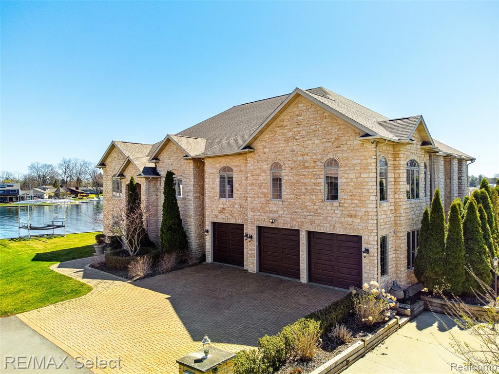 Welcome to 13229 Enid Boulevard — a stunningly renovated lake home nestled in the heart of charming Fenton! This exceptional residence offers the perfect blend of modern luxury and timeless style, just steps from beautiful Lake Fenton.

The main floor showcases gorgeous brand new flooring, updated lighting, and fresh paint throughout, while the upper level features plush new carpeting for added comfort. Elegant new ceiling fans enhance both style and efficiency. The heart of the home is the chef’s kitchen, thoughtfully designed with high-end finishes including a gourmet Wolf stove, three ovens, warming drawers, soft-close cabinetry, and multiple Sub-Zero refrigerators — a dream come true for any culinary enthusiast. The first-floor bar is equipped with a wine fridge and a premium built-in Sub-Zero ice maker—perfect for hosting with style.

The main floor primary suite offers a serene retreat with a spa-like bath, scenic views, and private outdoor seating — the perfect place to enjoy your morning coffee. Upstairs, you'll find five spacious bedrooms, each with ensuite baths and walk-in closets for ultimate comfort and privacy.

Additional highlights include a versatile second kitchen with newer appliances, ideal for entertaining or multi-generational living, a large loft for casual gatherings or game nights, and a private theater room with reclining seating and a wet bar — perfect for movie lovers. A dedicated office/workout room upstairs boasts peaceful water views, creating a tranquil, inspiring space. With laundry rooms on both floors, convenience is built right in.
Enjoy water activities right outside your door, and take advantage of nearby restaurants for dining and entertainment. Lake living at its finest – where every day feels like a vacation!