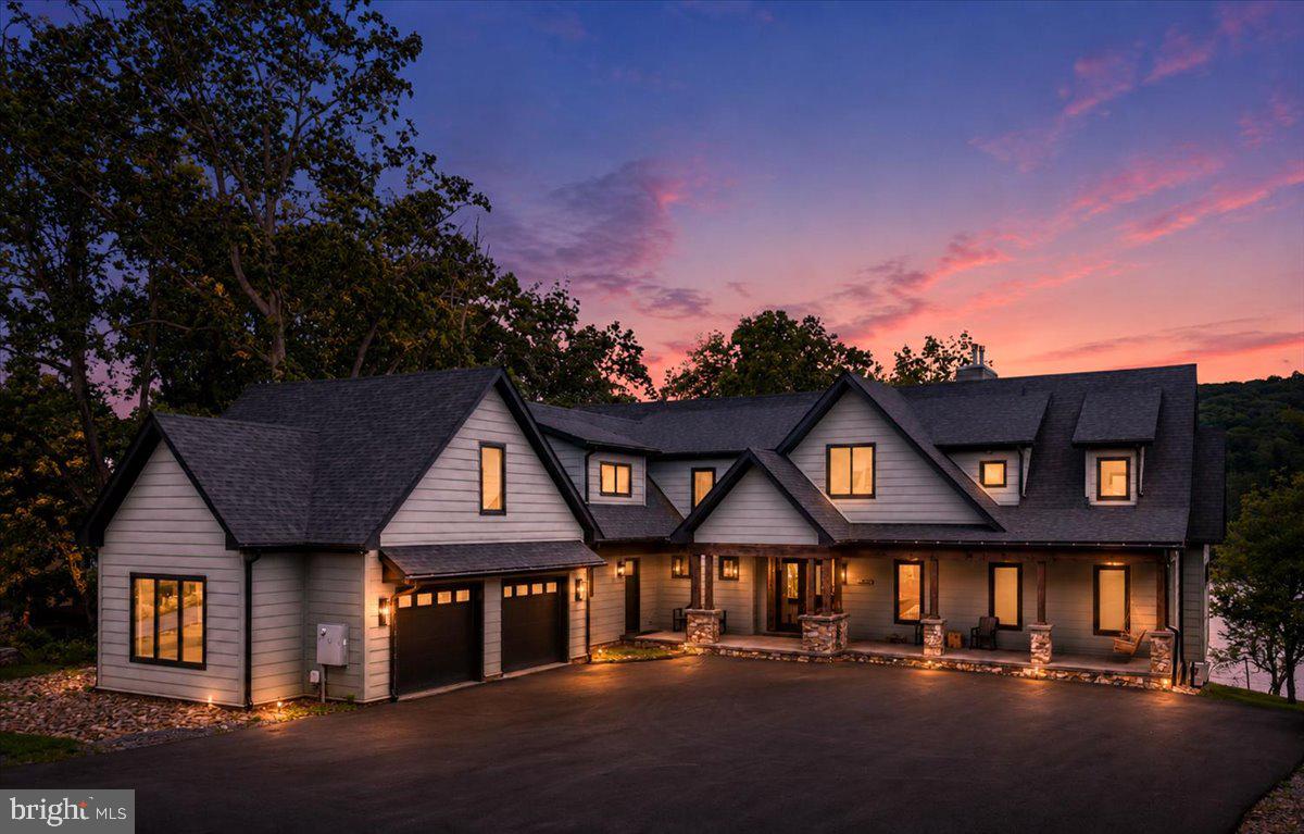 Welcome to "Stone Manor", one of Deep Creek Lake's most extraordinary waterfront estates.Custom built in 2023 by renowned builder Don Nemith and beautifully curated by Juniper Interiors, this remarkable lakefront retreat blends timeless craftsmanship, luxury design, and exceptional investment potential. Situated on nearly an acre with 108.9 feet of level lake frontage and a coveted Class A private dock, the property offers over 8,300 square feet of thoughtfully designed living space in one of Deep Creek Lake's most desirable locations.Paying homage to the property's rich history, the owners incorporated stone from the original Stone Manor into the construction and landscape design, creating a one-of-a-kind residence that honors the past while delivering every modern luxury imaginable.Inside, you'll find 5 bedrooms, 6 full baths, 1 half bath, soaring ceilings, expansive gathering spaces, designer finishes, and walls of glass that frame breathtaking lake views throughout the home. The spectacular indoor pool creates a true four-season resort experience, while multiple indoor and outdoor entertaining areas were designed for unforgettable gatherings with family and friends.The exterior is equally impressive, featuring extensive custom hardscaping, an outdoor kitchen, multiple lakeside entertaining spaces, and easy access to the private dock just steps from the home. A massive 4-car garage provides exceptional space for vehicles, boats, lake toys, and storage.Currently operating as the highly successful Stone Manor vacation rental, the property has generated an average of $201,000 in annual gross rental revenue, offering established income potential alongside luxury lakefront ownership.One of the few newer luxury homes on Deep Creek Lake offering a Class A dock, indoor pool, and proven six-figure rental history, Stone Manor presents a rare opportunity to own a private waterfront resort in the heart of Deep Creek Lake. Conveniently located just minutes from Wisp Resort, golf, marinas, restaurants, and year-round recreation.Offered fully furnished and turnkey. Shown by appointment only. Call today for your private tour.