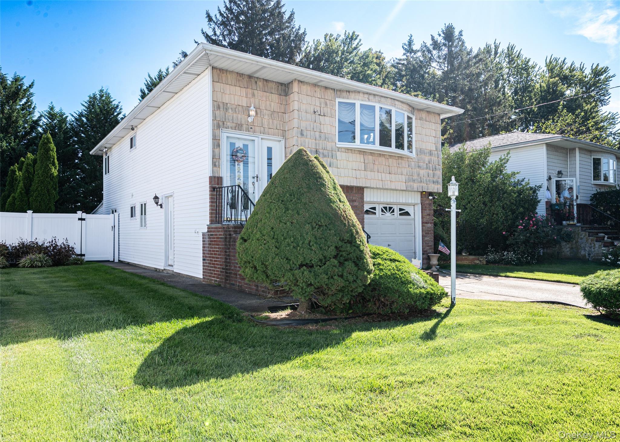 Welcome to 34 Scherer Street, a beautifully maintained Hi-Ranch nestled in the heart of Bethpage within the Brenner Estates neighborhood. This spacious 3-bedroom, 2-bath home offers a comfortable and flexible layout with nearly 1,900 square feet of living space.

The main level features a bright open-concept living room with vaulted ceilings, skylight, and a large bay window that fills the space with natural light. The formal dining area is highlighted by a striking chandelier and flows seamlessly into the eat-in kitchen, which offers vaulted ceilings, a skylight, glossy cabinetry, stainless-steel appliances, and ample counter space.

The primary bedroom provides direct access to the full hall bathroom, creating a convenient semi-private setup. Two additional bedrooms complete the upper level, each offering generous space and versatility for guest, office, or hobby use.

The lower level expands the living space with a large family room featuring a wet bar and sliders leading to the backyard, ideal for entertaining or relaxation. This level also includes a full bathroom, a laundry/boiler room, and direct access to the attached garage for everyday convenience.

Outside, enjoy the patio overlooking the lush, level backyard—perfect for outdoor dining or quiet evenings. The property sits on a 6,000 sq ft lot (50x120) with manicured landscaping and a private, fenced setting.

Located just minutes from Bethpage State Park, residents can enjoy access to world-class golf courses, hiking trails, and open green spaces. The community also offers Tobay Beach access, a local pool and ice-skating rink, and the newly renovated Borella Field for sports and recreation. With access to Route 135, nearby shopping, and a variety of popular local restaurants, this location provides the perfect blend of suburban comfort and everyday convenience.