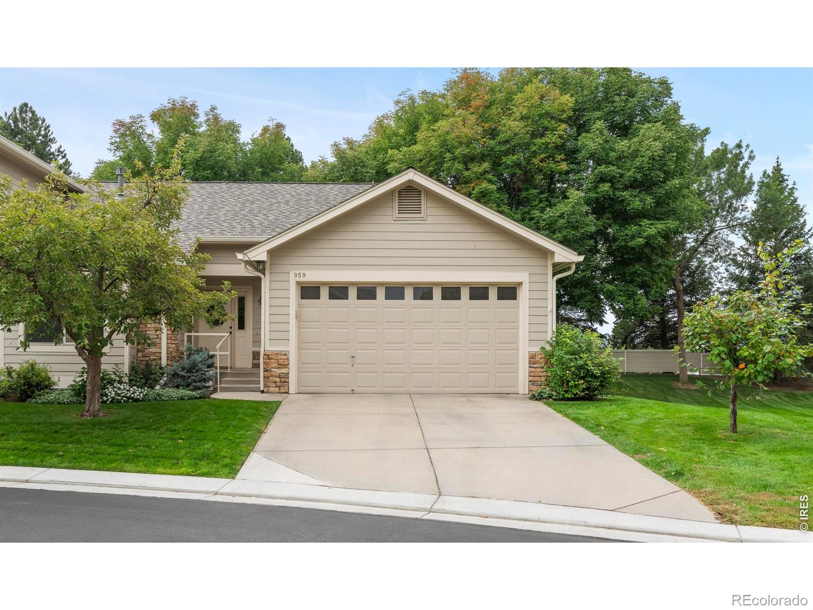 Beautifully renovated and designed for main-level living, this end-unit townhome pairs elevated interiors with a private setting beside HOA open space and peekaboo mountain views. Vaulted ceilings and abundant natural light create an airy first impression, while thoughtful updates bring a fresh, modern feel throughout the home. Step inside to an open floor plan where the kitchen and living room have been completely reimagined for both everyday living and entertaining. The renovated kitchen showcases new cabinetry, countertops, sink, appliances and lighting, flowing seamlessly into the living area. Here, an updated shiplap fireplace is framed by custom built-ins and open shelving, creating a warm, architectural focal point within the space. Just beyond, doors open to a private, fully enclosed patio - an intimate outdoor retreat overlooking the neighboring open space and mountain scenery. The main-level primary suite offers the ease of single-floor living with a spacious walk-in closet and a 3/4 en-suite bath featuring a beautifully renovated shower. A second main-floor bedroom provides flexibility as a guest room or dedicated home office, accompanied by an additional full bathroom. Main-level laundry further enhances the home's convenient, functional layout. Downstairs, the finished basement dramatically expands the living space. A massive second living area offers room to gather, unwind, create a media space or accommodate a variety of uses. Two generously sized conforming bedrooms, each with large walk-in closets, provide comfortable and private accommodations for guests, family or additional work-from-home space. A fully renovated bathroom completes the lower level. A new roof installed in 2024 adds peace of mind, while extensive interior renovations make the home feel fresh, elevated and move-in ready. With four bedrooms, multiple living spaces and true main-level living, 959 Hover Ridge Circle offers the space of a larger home with the ease of townhome living.
