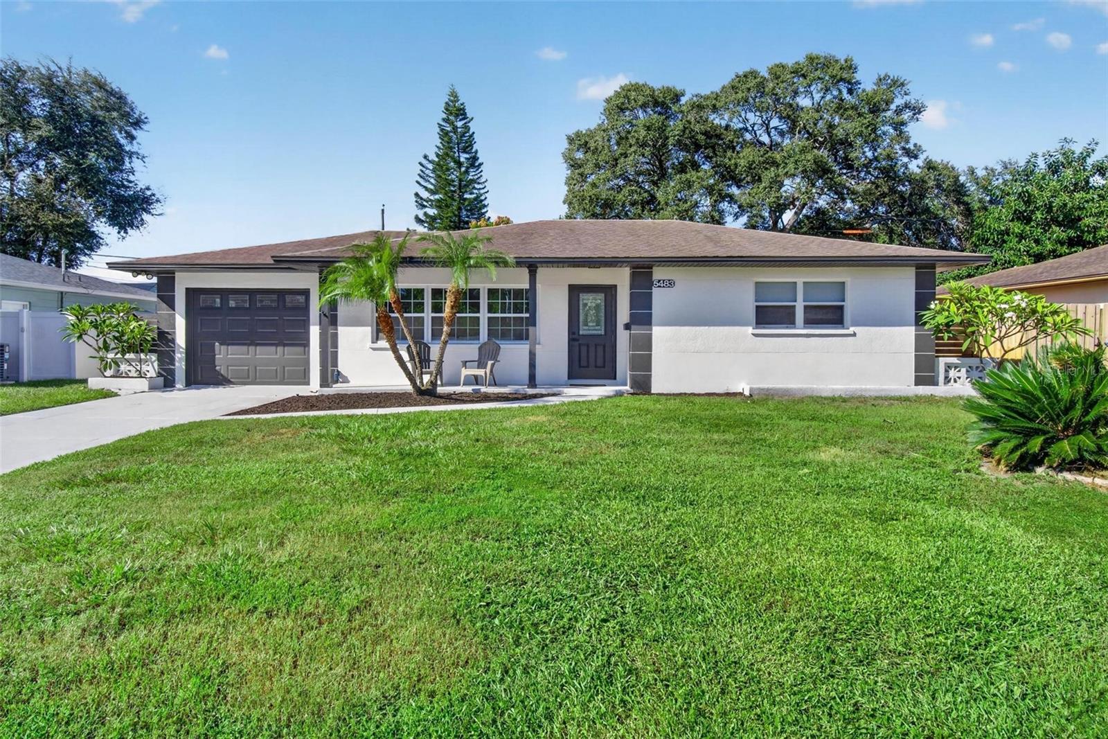 This beautifully updated block home is located in one of St. Petersburg’s most desirable neighborhoods and sits in a non-flood zone, offering peace of mind and long-term value. The bright, modern interior features an open-concept layout with new ceramic wood-look tile flooring, recessed lighting, and a clean, neutral design that appeals to today’s buyers. The stunning kitchen anchors the living space with soft-tone cabinetry, black hardware, quartz-style counters, stainless steel appliances, a spacious island with seating, and a sleek black sink overlooking the backyard. The living and dining areas flow seamlessly, creating an ideal setup for entertaining or everyday comfort. The home offers three bedrooms, including a versatile third bedroom that can function as a flex space, office, or guest room, giving buyers valuable options for work, hobbies, or additional living needs. All bedrooms are bright and inviting with fresh finishes and updated fixtures. Both bathrooms have been fully updated with designer tile, glass-enclosed showers, black fixtures, and high-end finishes, and the primary bathroom features an illuminated mirror that adds a modern touch. Outside, enjoy a fully fenced yard with mature trees, open green space, and plenty of room for pets, gatherings, or future outdoor enhancements. The property also includes a one-car garage, providing secure parking and additional storage. The front exterior is clean and welcoming with fresh landscaping and a charming porch. This prime location places you minutes from downtown St. Pete, close to our award-winning white sandy beaches, and just 20 minutes from two international airports, offering unmatched convenience for work, travel, and leisure. With its modern upgrades, block construction, non-flood zone location, fenced yard, garage, and move-in-ready presentation, this home stands out as one of the best values on the market. Homes like this do not last — schedule your showing today.