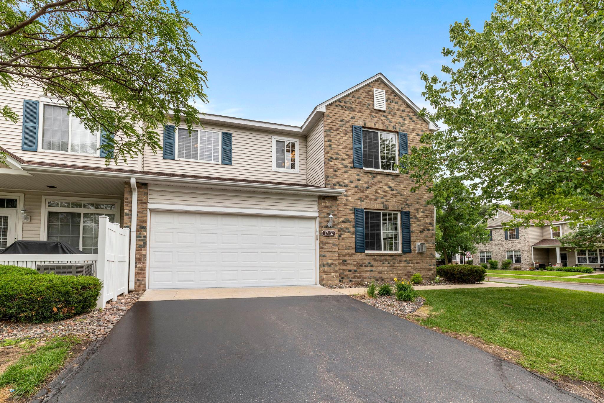 Welcome to this bright, open end-unit townhouse with three bedrooms and two bathrooms in the heart of Elk River. With The Woodlands Trails Regional Park, Lake Orono, 1,444 acres of parkland, and 31+ miles of trails nearby, plus easy access to shopping, dining, and Highway 10, this location truly has it all.The main level flows effortlessly from the living room through the dining area and into the kitchen. The living room features side and front yard views, a gas fireplace, and a classic mantle. The kitchen is well-appointed with a breakfast bar, peninsula seating, ample cabinetry, full tile backsplash, a large walk-in pantry, and laminate flooring. A half bath and garage access are conveniently tucked just off the back.The attached two-car garage includes built-in storage shelving. Upstairs complete with new crpet throughout (2026), the primary suite offers a spacious walk-in closet and private access to a walk-through bathroom. Two additional bedrooms bring in abundant natural light. The laundry room rounds out the upper level with cabinetry, a sink, and open shelving.HOA fees cover lawn maintenance and snow removal, with shared parks and playgrounds included. Thoughtful layout, low-maintenance living, and a location surrounded by nature and everyday convenience.