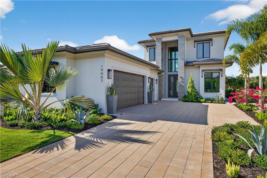 View of front of property with stucco siding, driveway, and an attached garage