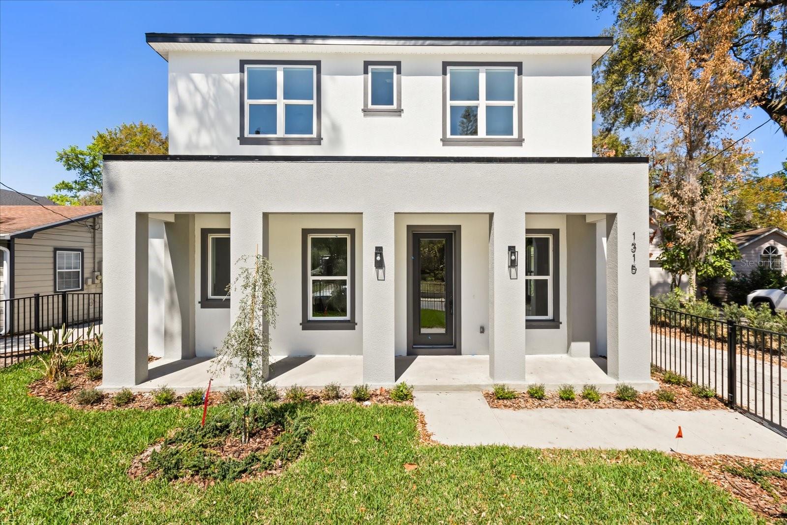Beautifully designed new construction just five doors from the Boone/Blanker K-12 campus in one of Orlando’s most desirable neighborhoods. Ideally located near I-4, the 408, Downtown Orlando, SoDo, the Milk District, and the Hourglass District, this home offers the perfect blend of style, function, and convenience. Inside, you’ll find a spacious great room, engineered wood flooring throughout with no carpet, and a sleek modern kitchen featuring quartz countertops, white cabinetry enhanced by ambient under-cabinet lighting, stainless steel appliances, a vented exterior range hood, and a two-tone wood-grain island with bar seating. The stunning downstairs half bath makes a bold impression with backlit built-in paneling and designer finishes. Upstairs, the oversized wood-encased staircase leads to bedrooms with wood flooring throughout, including a large primary suite with a barn-door-entry walk-in closet and a stylish bath showcasing high-gloss tile and modern finishes. The guest bath is equally impressive, and the oversized upstairs laundry room offers abundant storage with floating shelves and linen space. Outside, enjoy a fully fenced front yard ideal for kids and pets, plus a rear-entry 2-car garage and irrigation system. Builder warranties include 1-year full coverage, 2 years on HVAC, plumbing, and electrical, and 10 years on structure and roof. Your kids can walk to school from kindergarten through 12th grade and you can enjoy the restaurants, energy, and lifestyle of this exceptional neighborhood.NOTE: The home behind this one is also for sale with the same finishes, a fenced in backyard & patio and a similar floor plan. Ask to see both!
