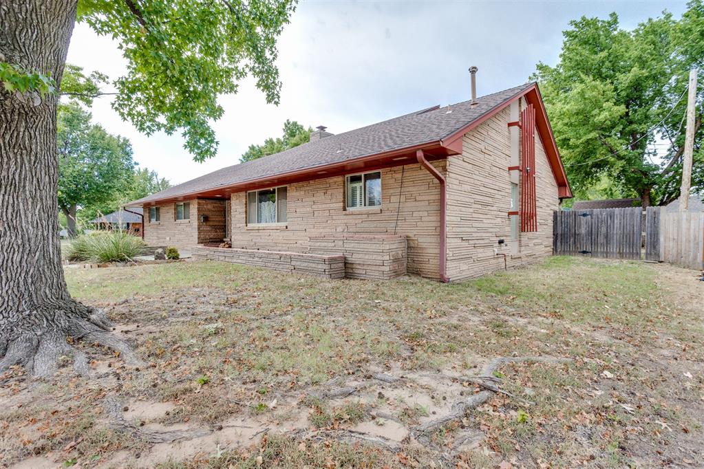 Unique Windsor Hills home offering 3 bedrooms, 2 full baths, and 2,039 sq ft on a corner lot in an established NW OKC neighborhood. Conveniently located near NorthWest 39th Street, major highways easy access to downtown OKC. Inside, vaulted ceilings, skylights, and a striking natural stone dividing wall create a distinctive first impression. Natural cedar paneling adds warmth to the entry and living room, centered around a wood-burning fireplace. The spacious living and dining areas provide an inviting gathering space, while the kitchen and bedrooms are thoughtfully separated for privacy. The kitchen features granite countertops and has been well maintained since its remodel around 15 years ago. Both bathrooms were also remodeled during that time. The primary suite offers a large bathroom with walk-in shower and generous walk-in closet. A defined flex area just off the kitchen provides a convenient space for a home office or study. Recent updates include fresh paint throughout the kitchen, kitchen dining area, hallways, and doors, plus new hallway carpet. Wood flooring runs through the living areas and bedrooms, with tile in the kitchen and bathrooms. Outside, enjoy mature oak trees, a fully wood-fenced backyard, covered pergola connecting the detached garage to the home, and a storage shed. The detached garage also features solar panels. A distinctive Windsor Hills property with character, updates, and an ideal location and is move-in ready and ready to make your own.
