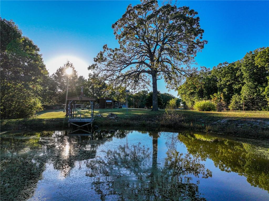 Property for Sale Truman LakeSet on 10.5 quiet acres just minutes from Truman Lake, this 3-bed, 2-bath home offers the perfect blend of comfort, functionality, and country living. A large back porch provides a great space to watch wildlife from the comfort of your home.  A separate guest living quarters adds flexibility for visitors or extended family. You’ll also find a well-built shop and a classic barn—ideal for projects, storage, or livestock. Off the side of the barn is a large fenced garden spot, with a well established asparagus patch.  Home For Sale St. Clair CountyThe land itself is a highlight. A fully stocked pond sits just beyond the home, perfect for a morning of fishing or an evening by the water. The property’s mature timber provides excellent hunting opportunities and plenty of space to roam. It’s the kind of place where you can step outside and feel miles away from everything, even though town and amenities are close by. Truman Lake and acres of Corps ground are just down the road, offering endless opportunities for boating, fishing, and outdoor recreation. Whether you’re looking for a full-time home or a peaceful weekend retreat, this property delivers a rare combination of privacy, space, and access to some of the best outdoor living Missouri has to offer. This property is just over an hour from both Springfield and Kansas City. Clinton is less than ½ hour drive, with a major hospital, and groceries.
