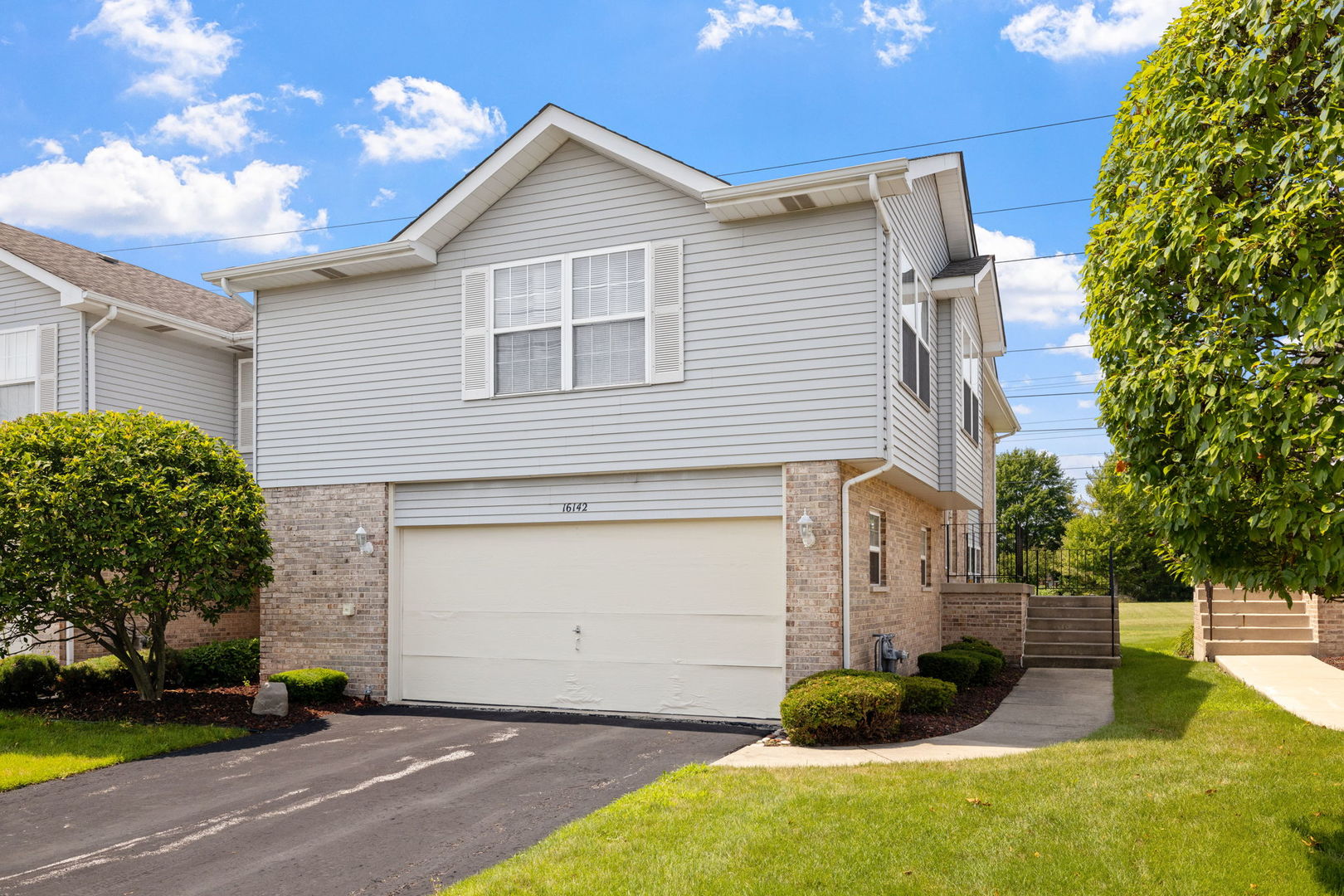 Tucked into the desirable Meadow Park subdivision, this clean and well-maintained end-unit townhome offers two finished levels of comfortable living and an attached two car garage. The main floor features an open-concept layout with a spacious kitchen that includes ample cabinet storage, room for a table, and a clear view into the combined living and dining area; perfect for everyday living and entertaining. Natural light pours in through the many windows, while sliding doors lead to an oversized, private deck that backs to open green space with no neighbors directly behind. Two generously sized bedrooms are located on the main level, including a primary suite with a walk-in closet and private access to the shared full bath. The finished lower level expands your living options with a bright family room, a second full bathroom, laundry room, and walk-out access to a second outdoor space. There's also potential to create a third bedroom on the lower level, offering flexibility for guests, a home office, or additional living space! Ideally located in the heart of Tinley Park, just minutes from shopping, dining, schools, parks, and entertainment.