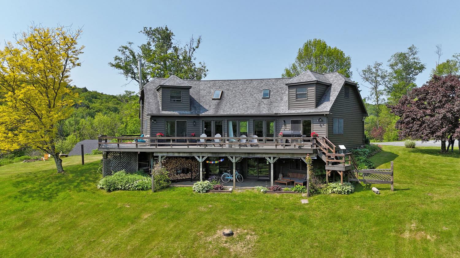 Back of house with a wraparound deck and covered patio underneath.