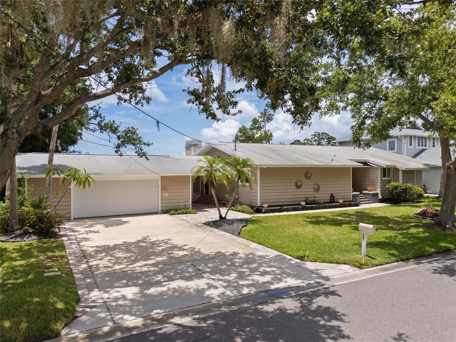 Ever dream of living on Lake Tarpon? Here is your Dream! Beautiful 4 BR home situated on a DOUBLE LOT WITH 120 FEET OF FRONTAGE ON LAKE TARPON, and you can fish right off your own COVERED BOAT DOCK and a BRAND NEW SEAWALL.  The home has been updated with GRANITE COUNTERTOPS, WOOD CABINETS, and STAINLESS STEEL APPLIANCES in the kitchen. Beautiful hardwood floors in the kitchen, dining area, family room, living room, primary bedroom, and plush carpeting in the other 3 bedrooms. Yes, of course, the family room has a fireplace! The OVERSIZED 2-CAR GARAGE (WITH A/C UNIT)  has room for a workshop and attaches to the home via a covered breezeway.   Large windows in the family room give you a spectacular view of the Lake. You do not want to miss this exceptional home on Lake Tarpon.