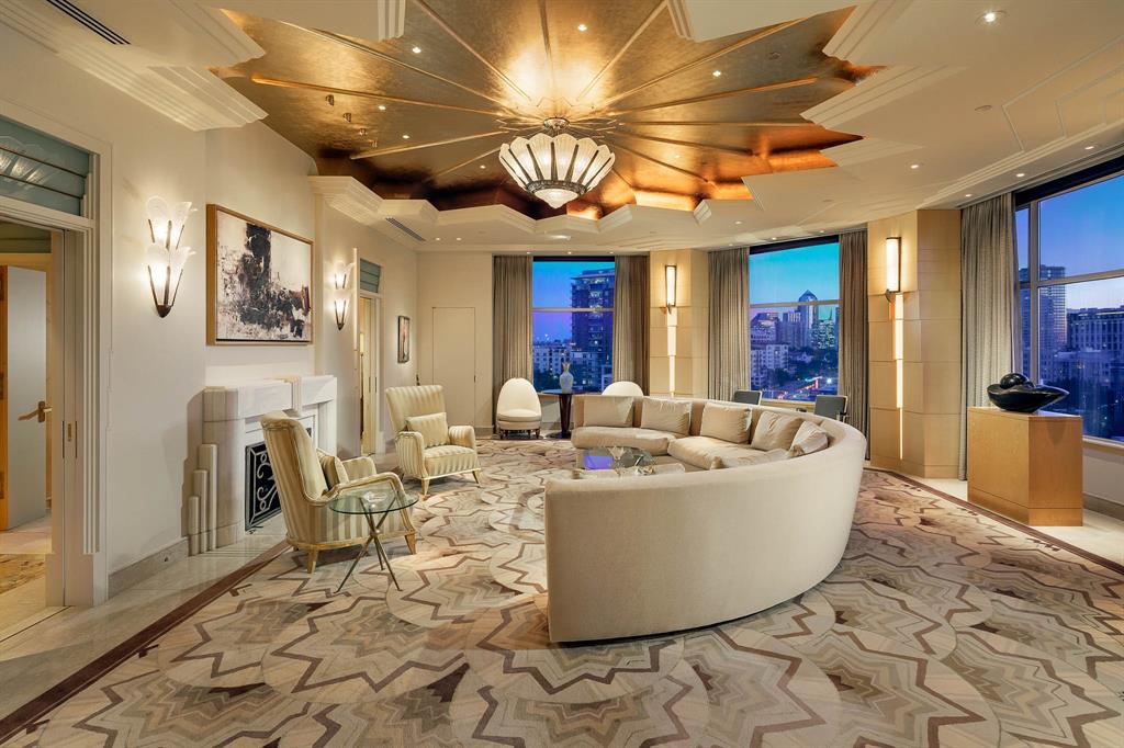 Offered fully furnished, Unit #8W at the Mansion Residences is designed for those who favor the bold. A first look introduces architect Darius Toraby’s concept — 5,302 square feet of Art Deco precision across a grand living room, library, multiple foyers & private terraces. A closer study uncovers the details: brass hardware cast from original molds used at the Paris Opera House, etched glass doors reproduced from Parisian estates, and marble that required three times the typical cutting to achieve perfect book-matching. The living room's gold-leafed cove ceiling frames a 1920 Salerno French light fixture — the very reason the ceiling exists at that height. In the powder room, a glass mermaid panel commands a space designed entirely around it: black marble floors, silver ceiling, and starburst hardware. The library's sycamore paneling was selected to complement specific art, its Roman fireplace finished with bronze end plates. Even utilitarian spaces hold intention. The kitchen's black lacquer cabinets and speckled granite make daily routines feel deliberate. The primary suite's dual bathrooms feature blue mirrored glass and Italian marble, complemented by heated floors and a coffee bar. A second bedroom suite and flexible spaces maintain the same standard: nothing here is an afterthought. Two private terraces — a rarity within the building's exclusive residences — extend living space outdoors with the downtown skyline as a backdrop. Throughout, wall segments are indented for specific art, and rugs are inset into the flooring. This level of specificity promises an invigorating challenge to decorate — but therein lies the reward. As a resident, you inherit twenty-four-hour security, valet, and private access to the hotel's restaurant. This address provides what most luxury buildings only approximate: true hotel-level service in a residential setting.
