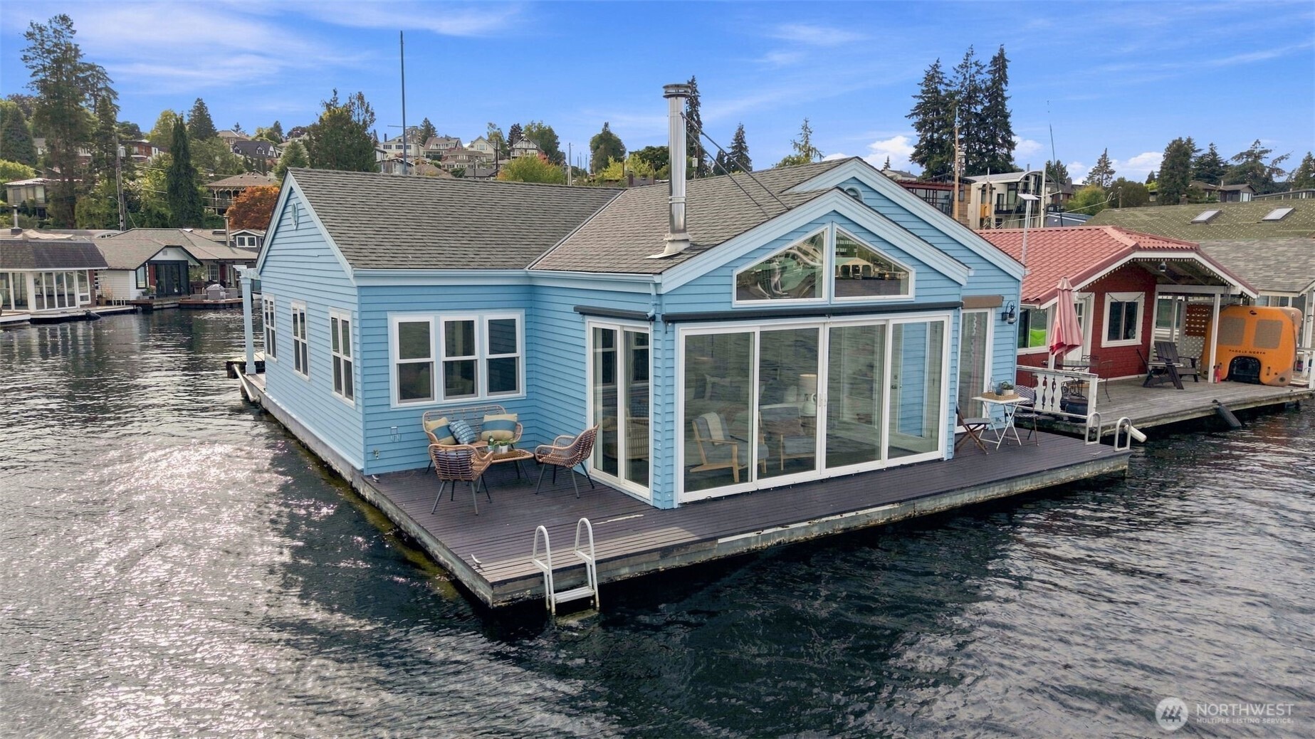 End-of-dock with uninterrupted views straight down the Montlake Cut, this rare front-row floating home offers the quintessential Seattle "houseboat" lifestyle. You own the moorage as a member of theco-op dock, complete with your own private boat slip, low-bank bulkhead waterfront, and two expansive decks designed for effortless outdoor entertaining, swimming, and launching your paddleboard. Inside, all-main-floor living features light-filled interiors, soaring vaulted ceilings, and gorgeous hardwood floors, all thoughtfully designed by architect Eric Hogeboom. The clever layout places the primary suite on its own with stunning water vistas and direct deck access, while two additional bedrooms sit on the opposite side of the home with dedicated bath space—all framed by brand-new windows ideal for taking in the summer boat parade or watching winter migratory birds. Freshly painted inside and out, packed with storage including an attic, and wrapped in panoramic views on three sides, this is an extraordinary opportunity to live right on the water.