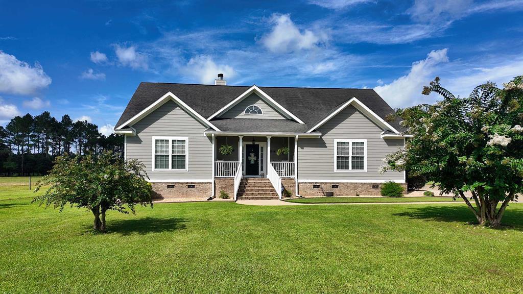 Gorgeous backyard views, gunnite/saltwater in-ground swimming pool, 4 bedrooms, 3.5 bathrooms, situated on nearly one acre.   128 Quail Ridge is tucked away at the back of a quiet cul-de-sac in Thomas County just 10 miles from Downtown Thomasville, schools, shopping, dining, and entertainment. This one and a half story residence showcases an inviting front porch and a gorgeous backyard with an in-ground pool surrounded by palm trees that's perfect for entertaining. Downstairs, there are 3 bedrooms and 2.5 bathrooms, and the upstairs bedroom offers plenty of space and complete privacy with its own bathroom.  The fenced-in backyard allows plenty of room for activities and events, and includes a timed sprinkler system and lights that makes upkeep easier. The outbuilding provides storage space for lawn equipment, boats, ATVs, and more! Inside you will find a comfy living room complete with a vaulted ceiling, fireplace, and built-in bookcases that opens up into a beautiful kitchen and dining room. The kitchen is every chef's dream with granite countertops with matching backsplash, ample cabinet space, and stainless steel appliances which include double ovens, dishwasher, built-in microwave, refrigerator, and freezer. Also included in the kitchen is a built in desk and home office.The main level master suite is spacious with a walk-in closet and a luxurious bathroom with a garden tub, walk-in tiled luxury shower, and double vanities. The other two downstairs bedrooms are connected by a charming Jack-and Jill bathroom, ideal for family and guests. The flooring downstairs is porcelain tile and upstairs is newly installed LVP.