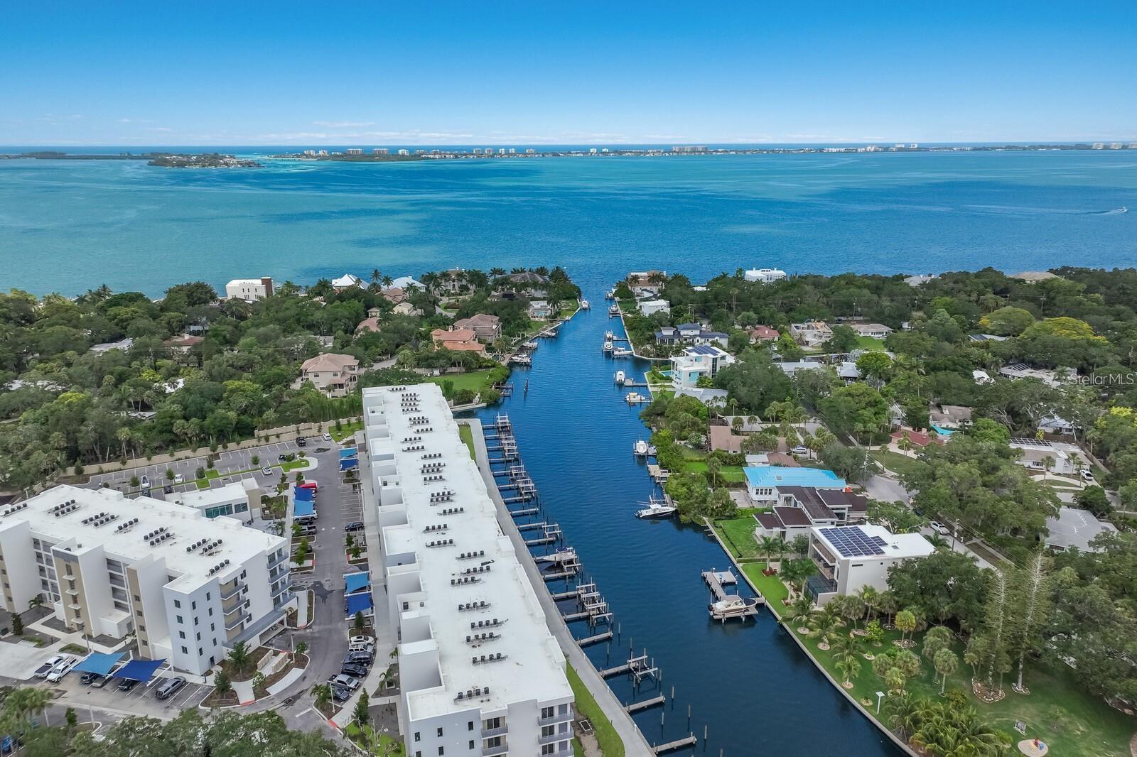WATERFRONT, WATCH BOATING, OCEAN LIFE AND SUNSETS FROM THIS PENTHOUSE AT THE STRAND. UNIT PRICE PH 519 DOES NOT INCLUDE A DEEDED BOAT SLIP AND LIFT BUT ONE IS AVAILABLE #31 WITH A 13000 LB LIFT FOR ($130,000.) EXTRA COST OF $243.00 QUARTER FOR ELECTRIC AND WATER.  A must see this Modern New Construction (2022) 5TH FLOOR CONDO. Turnkey furnished with the perfect furnishes. Move in ready. Step into luxury and enjoy the incredible Water Views! You will immediately want to walk to the 8 Foot 4-Panel hurricane rated Sliding Glass Doors to your private balcony to enjoy the gorgeous sunsets, and you will be entertained daily by a variety of Birds, Dolphins, Manatees, Boats, Kayakers, Paddleboarders. The Kitchen/Dinning/Living Room offers a large, bright, open floor plan. The Kitchen is upgraded to the Modern Glossy light Cabinets and paired with stylish darker Quartz countertops. The large Island with modern lighting is perfect for entertaining, eating, working, or to just gather around. The Primary Bedroom is a nice King Bed size, tall ceilings, and a window with Bright Morning Sun with a view of the Pool. The Primary bathroom has upgraded tile throughout, Modern Cabinetry, Quartz Countertops, Glass Shower Door, and a Window Streaming Natural Light. You enter the Den/2nd Room through the very popular modern Barn doors. This den is large enough to be used as a 2ND BEDROOM and currently has a queen bed/ OFFICE or BOTH. It also has an X-LG wall to wall closet for additional storage and TV. tHIS IS THE SAME SQ FT AS A 2 BEDROOM.The Laundry Room has a full-size Samsung Washer and Dryer with new cabinets. The Guest Bathroom boasts Modern Cabinetry, Quartz Countertops, and a Shower/Bath combo. This high-end condo has upgraded Luxury Vinyl Planks throughout along with Modern Lighting and Fans and window treatments. The Awesome part of living in The Strand are the amenities and close proximity to all who come to Sarasota for restaurants, beaches and shopping. Pet friendly and walk with them around the friendly community or play in the fenced dog park. Kayaking is available and launch from your own community Floating Dock. Catch some rays, take a dip in the Resort Style Heated Pool/Spa, or get a workout in the Well-Equipped Gym. There are Car charging stations too! Take a Walk around the Gated Community, grill out at the community gas grills, or bring a beverage and Relax at the Gas-Fire Pit. All of this is located in one of the BEST places to live. How exciting to live within 2 miles of three Waterfront Parks? Whitaker Park, The BRAND-NEW Bay Park, and the Bayfront Park are all super close! Drive, Bike, or Walk to Downtown especially on Saturday during the weekly Farmers Market. Walk to the Wicked Cantina and enjoy their Yummy Chips and Salsa, or head Downtown for dozens of restaurants of many different varieties. Lido beach and St. Armand's circle are only 5 miles away and Siesta Key beach is 8.6 miles away. Sarasota has Museums, Theaters, Opera, Beaches, Symphony, Parks, Yoga, Shopping, Golf Courses, Restaurants. INCOME HAS BEEN $3500 PLUS ELECTRIC OFF SEASON AND $6000 IN SEASON. ALWAYS  BEEN RENTED.  OWNWER CANNOT CLOSE BEFORE MAY 16, 2026 CALL AGENT DIRECT.