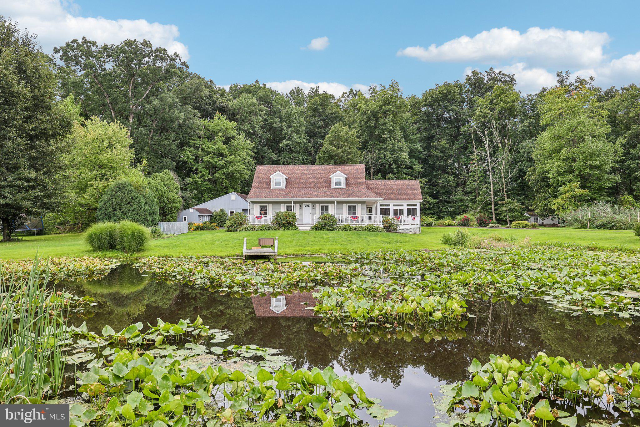 Welcome to 117 E Conestoga Road, a truly one-of-a-kind Cape Cod set on 1.29 picturesque acres where the setting is every bit as special as the home itself. With two ponds, wooded surroundings, beautiful outdoor spaces, and room to enjoy it all, this is a property that feels like a private retreat from the moment you arrive.A welcoming wraparound front porch sets the tone and offers the perfect place to sit, take in the peaceful surroundings, and enjoy views of the property. Here, life naturally moves outdoors. Launch a canoe or kayak, spend an afternoon by the water, tend to the garden, or simply enjoy the quiet of having two ponds and a wooded backdrop right outside your door.Step inside to a bright, open floor plan filled with natural light and warm, inviting spaces. A dedicated office provides a private place to work or study, while rich Brazilian Cherry hardwood floors lead you into the living room, where a beautiful stone fireplace creates a cozy focal point.The formal dining room offers plenty of space for holidays and gatherings, while the sunroom just beyond may quickly become one of your favorite rooms in the house. Surrounded by views of the property, it is an ideal spot for morning coffee, a good book, or simply watching the seasons change.At the heart of the home is the spacious kitchen, thoughtfully designed for both everyday living and entertaining. Upgraded countertops, a generous center island, stainless steel appliances, and a casual breakfast area create a space where everyone will naturally want to gather.When the day winds down, the primary suite offers a private retreat with generous closet space and a beautifully updated en-suite bath featuring a large walk-in shower. Upstairs is a spacious loft, 2 additional bedrooms and full bathroom which provide plenty of flexibility for family, guests, hobbies, or additional work-from-home space Outside is where this property becomes something truly extraordinary. The wraparound porch, rear deck, garden, wooded surroundings, and two ponds create an outdoor lifestyle that is increasingly hard to find. Imagine summer dinners on the deck, mornings by the water, afternoons in the garden, or grabbing a kayak and heading out onto the pond without ever leaving home.An oversized detached garage with walk up second floor and enclosed room adds even more versatility, with abundant room for vehicles, recreational equipment, storage, or a workshop. Additional shed with electric is perfect for a woodshop.117 E Conestoga Road is not simply a beautiful home on 1.29 acres. It is a property with personality, privacy, recreation, and a setting you simply cannot recreate. Two ponds, a garden, wooded views, generous indoor and outdoor living spaces, and the feeling of having your own little piece of Pennsylvania countryside make this Elverson home something truly special.