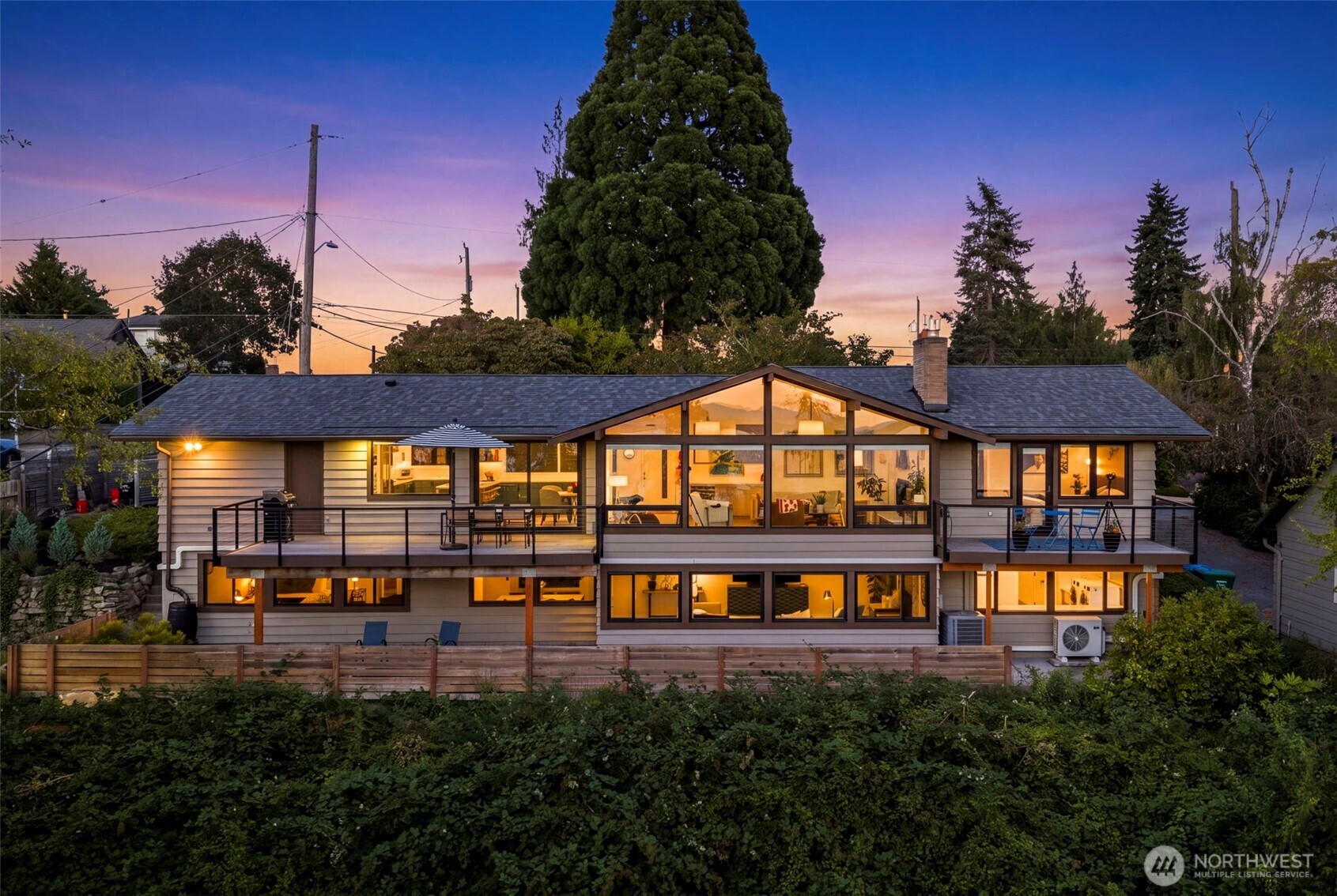 Set against a panoramic Puget Sound backdrop, this thoughtfully updated mid-century modern home offers captivating water views and a front-row look at the Fauntleroy ferry. Walls of windows frame the waterfront backdrop, bringing natural light and the rhythm of the Sound into the home's main living spaces. The living room flows seamlessly into the dining area and open, modern kitchen, creating an inviting layout. The main level features a spacious primary suite with a pass-through walk-in closet and ensuite bath, plus a guest bedroom and full bath. Downstairs offers a spacious second living area, an additional bedroom, workout room, and oversized laundry room. Attached garage with EV charging. A well-balanced blend of original character and modern updates creates a home that is comfortable, functional, and ready for its next chapter.