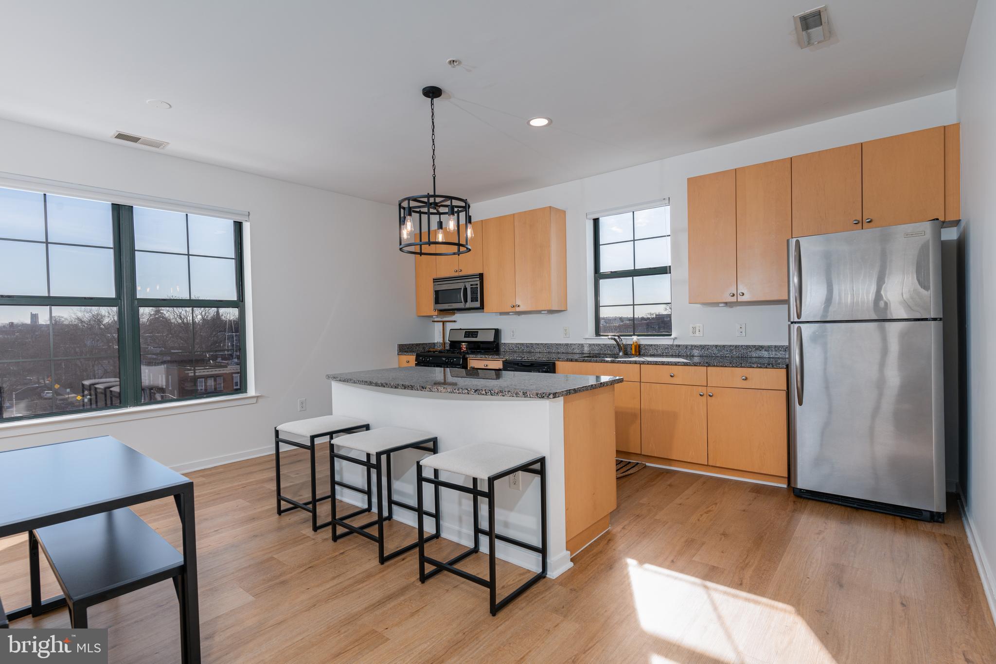 Welcome to unit 408 in the Village Lofts! This bright and sunny top floor corner unit condo has been nicely updated and ready for you to move in! The 1bd/1.5ba condo offers a spacious and open floor plan and is perfect for entertaining guests. The living room has a large footprint and can easily accommodate all of your furnishings, has access to the private balcony and opens nicely to the kitchen. Featuring ample cabinetry, a large island, and granite countertops, the kitchen offers all of the modern amenities you need to feel right at home! The bedroom is enormous and can fit a king-sized bed while offering plenty of closet storage. There is a private ensuite bath with dual vanities and a tub/shower combo. Plus, there is a bonus half bath for guests when they visit and in-unit laundry! Updates to the condo include brand new flooring, fresh paint, new light fixtures, blinds and more. The condo offers deeded parking and is just steps from JHU! Stop in today, this one won't last long!