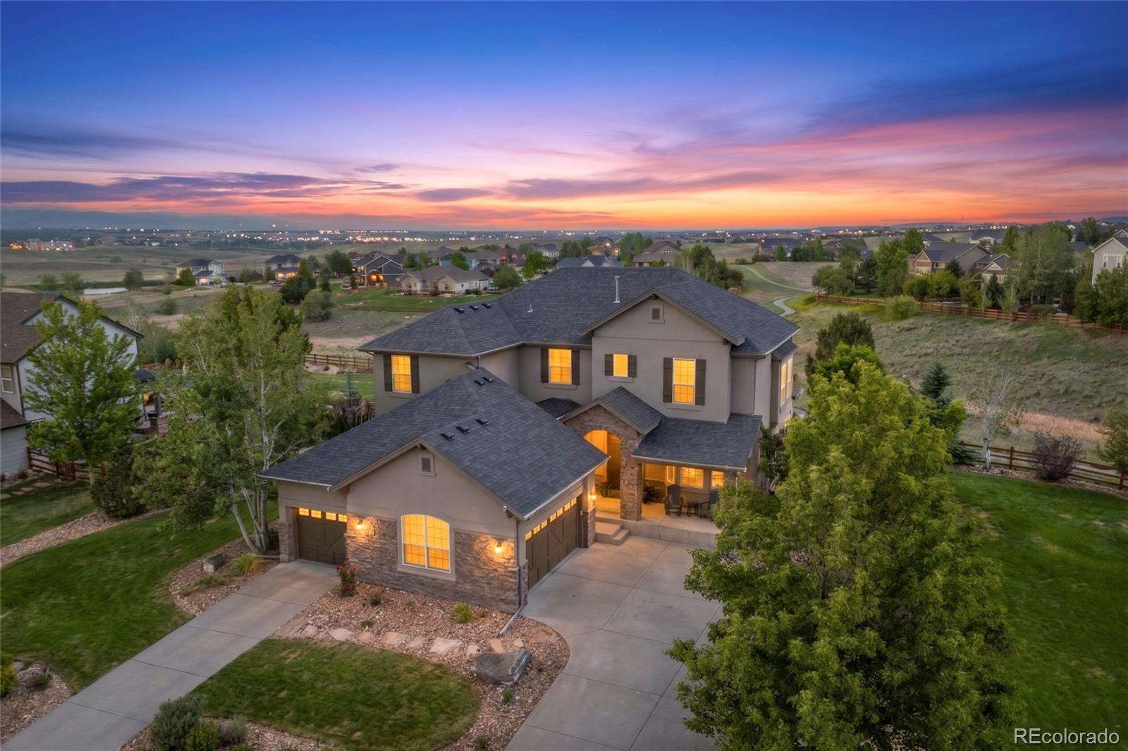 Perfectly situated on one of Wildgrass' most sought-after homesites, this exceptional property offers an expansive ½-acre setting with stunning, unobstructed mountain views and access to the highly regarded Boulder Valley School District. Surrounded by open space and neighborhood trails, this home truly captures the best of Colorado living. The beautifully landscaped backyard has matured into a private and peaceful retreat, featuring a tranquil water feature, spacious covered patio with built-in heaters, built-in grill and firepit, and a pre-wired hot tub pad. This outdoor space is special for entertaining and enjoying sunsets! Inside, thoughtful updates create a fresh, modern feel while classic white cabinetry provides timeless appeal. Modern LVP flooring flows throughout the main level, complemented by abundant natural light and a bright, inviting atmosphere. A main-floor study offers an ideal work-from-home space, while the well-appointed kitchen features stainless steel appliances, double ovens, a gas cooktop, and an easy connection to the adjacent family room. Upstairs, you'll find 4 spacious bedrooms and 3 beautifully finished bathrooms, all featuring a crisp white palette. The primary suite takes full advantage of the incredible views and features an updated bath with quartz countertops, a soaking tub, and an exceptional custom closet system. The finished basement adds incredible versatility with a spacious rec room complete with a custom bar, cozy fireplace, projector and screen—perfect for movie and game nights or gathering with friends and family. A 5th BR easily functions as a guest room, home gym, quiet office, or hobby space. Wildgrass is one of Broomfield's most beloved communities, offering a pool, clubhouse, tennis courts, parks, and miles of trails woven throughout protected open space. With its rare homesite, incredible views, thoughtful updates, and exceptional outdoor living spaces, this is truly one of the neighborhood's special homes.