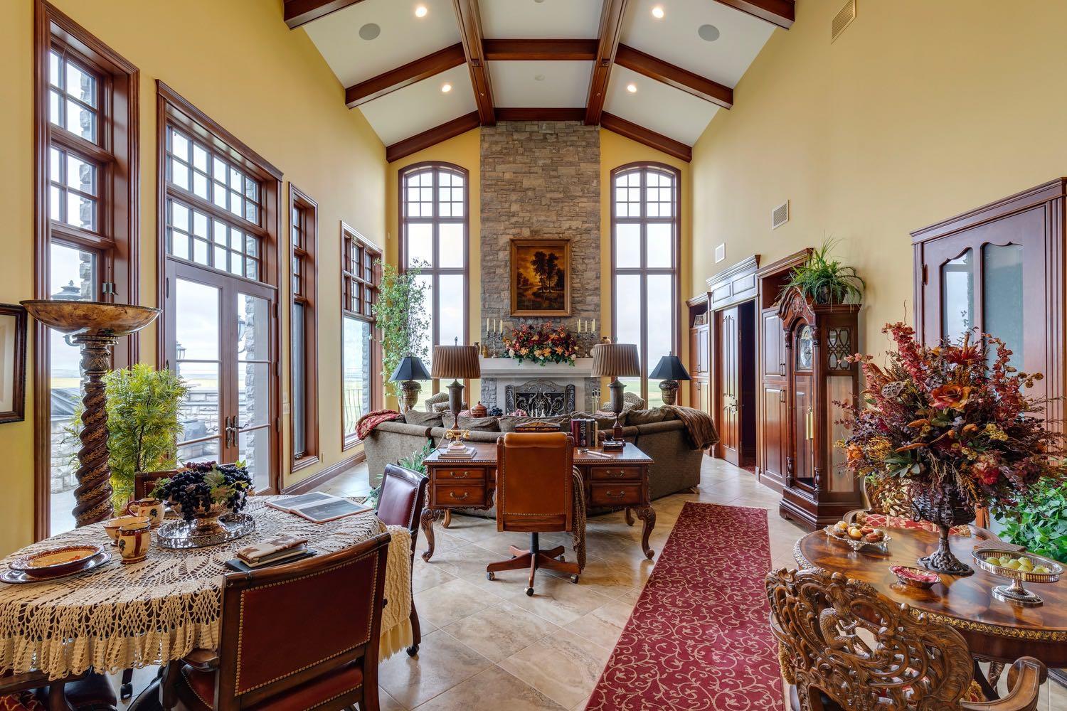 For the discerning luxury buyer seeking a legacy-calibre landholding beyond the confines of the city, this extraordinary 160-acre estate in Alberta’s Kneehill County offers a rare convergence of privacy, scale, luxury, and long-term vision. Located less than an hour from Calgary and YYC International Airport, the property is ideally suited for multigenerational living, a private family retreat, luxury rural hospitality venture, wellness destination, or significant investment holding. Encompassing over 13,000 sq. ft., the custom stone-clad manor was built with uncompromising craftsmanship and a “custom everything” philosophy, featuring rich cherry oak millwork, bespoke cabinetry, Cheryl Wagner gold fixtures and hardware, soaring ceilings, statement chandeliers, seven gas-lit wood-burning fireplaces, and integrated Crestron smart-home technology throughout. Designed for elevated entertaining and large-scale family living alike, the residence offers seven bedrooms, fourteen bathrooms, an elevator servicing all levels, a showpiece chef’s kitchen with premium appliances and butler’s pantry, secondary preparation kitchen, nanny/in-law suite, two theatres, wine room, library, gym, steam room, spa, and an additional full kitchen on the lower level. Expansive terraces, an outdoor kitchen, private courtyard spaces, and a newly constructed year-round enclosed solarium create a seamless connection to Alberta’s dramatic prairie landscape. Purposefully designed for resilience and self-sufficiency, the estate includes a 3,000 sq. ft. guest residence, private helicopter landing pad, 22,000 gallons of water storage, CAT D80-2S backup generator, attached triple garage, and detached collector’s garage connected via underground tunnel. A substantial 180x80 machine shop presents exceptional flexibility for equestrian infrastructure, luxury event use, wellness expansion, or private collector purposes. Rarely does a property emerge that so completely answers the growing demand for experiential luxury, privacy, and meaningful generational ownership in Western Canada.