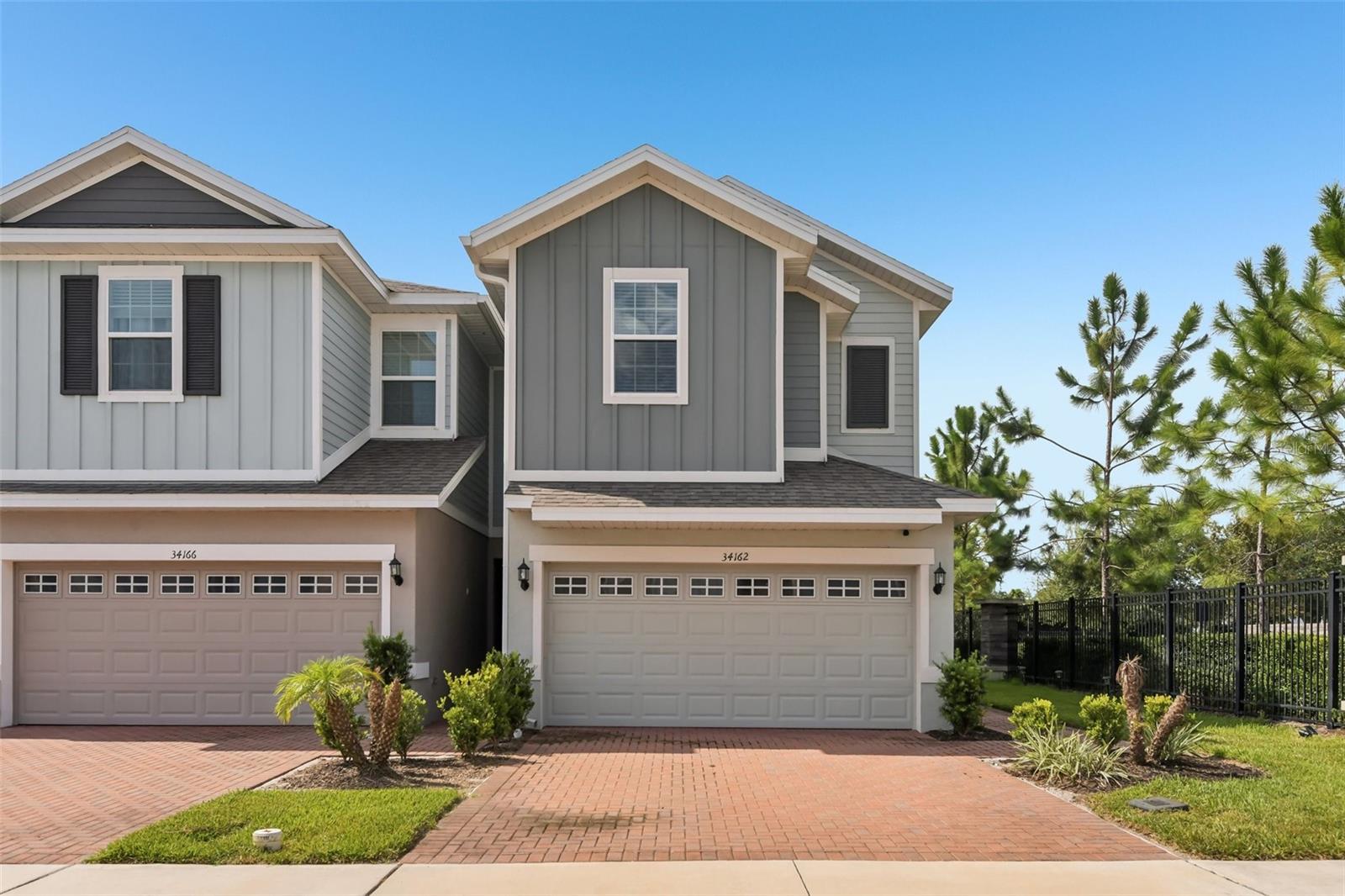 This 2023-built townhome has been lovingly cared for by the original owner and is an end unit located near the front of the community. From the moment you arrive, the brick paver driveway and 2-car garage provide great curb appeal and everyday convenience. Inside, an inviting open floor plan features high ceilings, recessed lighting, neutral finishes, and tile flooring throughout the main level. The spacious kitchen is designed for both everyday living and gathering, featuring granite countertops, stainless steel appliances, a large center island with pendant lighting, and a convenient breakfast bar. A downstairs powder room adds functionality for guests.Upstairs, the versatile layout includes 3 bedrooms, 2 full bathrooms, and a loft, providing flexible space for a home office, media area, or additional living space. The split-bedroom design offers privacy, while the spacious primary suite creates a relaxing retreat with a tray ceiling and a large en suite bathroom featuring dual sinks, a glass-enclosed shower, and a huge walk-in closet.Step outside to the brick paver back patio, the perfect spot to enjoy your morning coffee or unwind at the end of the day. As an added bonus, residents have access to a community pool. Meticulously maintained and move-in ready, this townhouse combines the benefits of newer construction with a low-maintenance lifestyle in one of Wesley Chapel's most desirable areas. With its end-unit location, 2-car garage, flexible loft space, modern finishes, and community amenities, this is an opportunity you won't want to miss.