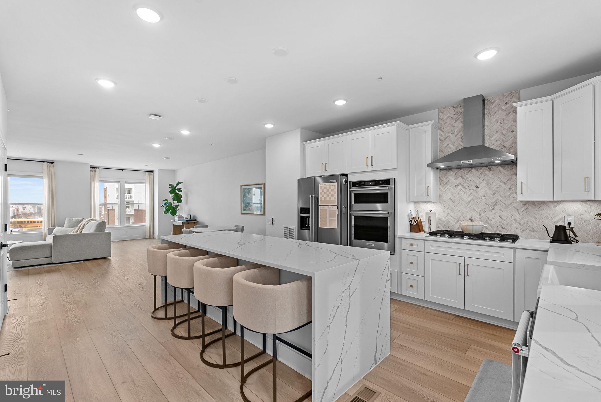 This beautifully maintained, like-new townhome is sure to impress from the moment you enter. The entry level offers a flexible space perfect for a home office or guest bedroom, highlighted by full-glass double doors. This level also features luxury vinyl plank flooring, a powder room, a coat closet, and convenient access to the rear-load two-car garage. Oak stairs lead to the bright and open main living level, where luxury vinyl plank flooring continues throughout. Designed for both everyday living and entertaining, this floor includes a spacious family room filled with natural light and anchored by an upgraded electric fireplace with a striking black marble surround. The gourmet kitchen is a true showpiece, featuring quartz countertops with a waterfall island, upgraded stainless steel appliances, a white ceramic apron-front farmhouse sink, designer backsplash, and a generous pantry. Just beyond the breakfast area, step out onto the full rear deck - an ideal setting for outdoor dining, grilling, or relaxing. The third level offers upgraded luxury vinyl plank flooring in the hallway and a spacious primary suite with upgraded carpeting and a large walk-in closet. The luxurious en-suite bath features dual quartz vanities, floor-to-ceiling tile, a soaking tub with a window above for added natural light, and an upgraded shower head. Two additional bedrooms with abundant natural light share a well-appointed hall bath with quartz countertops and upgraded tile finishes. The laundry area is conveniently located on this level. The fourth level provides even more versatile living space with a large loft, perfect for a media room, playroom, home gym, or reading retreat. An additional bedroom, full bath, and spacious storage closet complete this floor. Glass sliding doors lead to a private rooftop terrace overlooking Belmont Chase, creating the perfect space to enjoy morning coffee, unwind by the electric fireplace, or entertain under the stars. Ideally located just moments from shopping, dining, grocery stores, coffee shops, and major commuter routes including Route 7 and Route 28, this home also offers easy access to INOVA Lansdowne and is only 20 minutes from Dulles Airport. Combining style, comfort, and convenience, this exceptional home is one you won't want to miss.