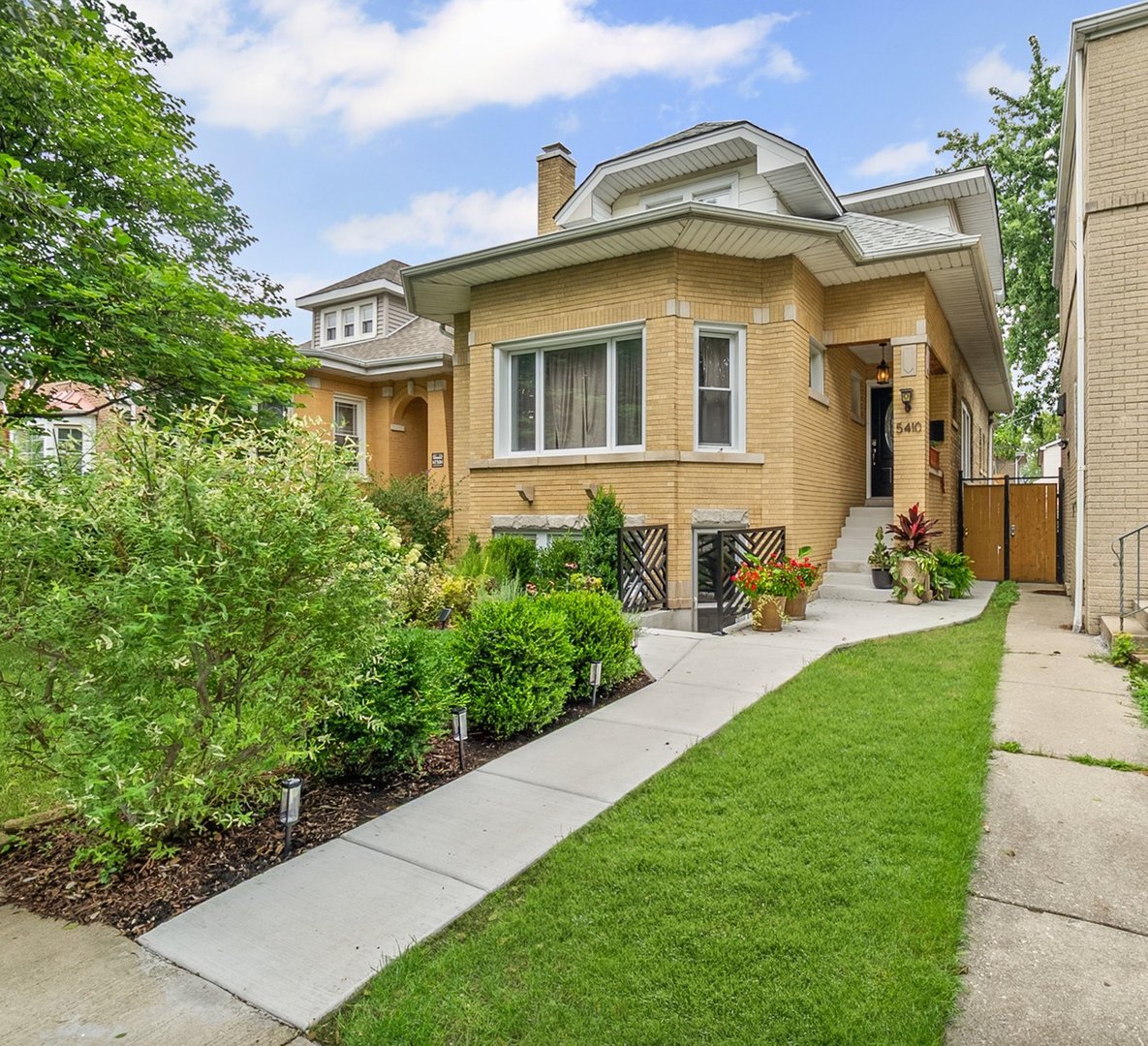 If you've been searching for a classic Chicago bungalow that perfectly blends timeless charm with modern style, your search ends here.   Welcome to 5410 W Hutchinson, a stunning oversized brick bungalow in the heart of Portage Park, one of Chicago's most vibrant and sought-after neighborhoods. With THREE levels of living space, 4 BEDROOMS, 3 FULL BATHROOMS and thoughtful updates throughout, this home is ideal for buyers who love city living but crave more space to grow.    Step inside and be greeted by gleaming hardwood floors, abundant natural light, and fresh paint throughout. The main level offers a bright and spacious living room with a cozy decorative  fireplace, a formal dining room, and a beautiful eat-in kitchen with sleek cabinetry and granite countertops. You'll also find a welcoming foyer, two bedrooms, a full bath, and mudroom with direct access to your beautiful backyard.     UPSTAIRS, you'll discover TWO BEDROOMS, including a large primary suite with generous closet space and endless design potential. The spa-like bathroom is a true retreat, featuring a walk-in shower with a rain shower head, a soaking tub, and designer finishes. Just steps from the primary suite, you'll find a wet bar paired with additional space that can be a perfect reading nook, home office, or relaxing lounge area.    Need more room? The fully finished LOWER LEVEL has been recently renovated with modern touches, including a stylish full bathroom with high-end finishes, recessed lighting, and ceramic tile throughout. You'll also find a beautiful wet bar with new cabinets and a backsplash. This level is ideal for an in-law suite, guest space, or an expansive family room, and features its own private entrance. The mechanical room is neatly tucked away, housing three separate water tanks and two high-efficiency HVAC systems.     Step outside to enjoy your private backyard oasis, fully fenced and recently stained. This yard is perfect for those summer gatherings and outdoor fun. The newly poured concrete patio features a large pergola, creating the ideal space for entertaining, dining, or simply relaxing. The professionally installed synthetic grass from ForeverLawn adds year-round beauty with minimal maintenance, while the sliding fence provides the option to easily park your vehicle.     Located just steps from PORTAGE PARK's 38 acres of green space, you'll enjoy tennis courts, pools, sports fields, and a vibrant community atmosphere. Popular coffee shops, restaurants, and classic Chicago architecture are right at your doorstep. Plus, with easy access to the expressway, Metra, and Jefferson Park transit hub, commuting anywhere is a breeze!    If you've outgrown your current space but want to stay connected to the energy of the city, this home offers the perfect solution!     RECENT UPDATES INCLUDE; newer light fixtures, two brand-new A/C units, tuck-pointing, new concrete patio and new concrete walkways, a beautiful pergola, a newer fence, foam insulation on the second level, New basement carpet, and so much more! Schedule your showing today! Your Portage Park dream home awaits!