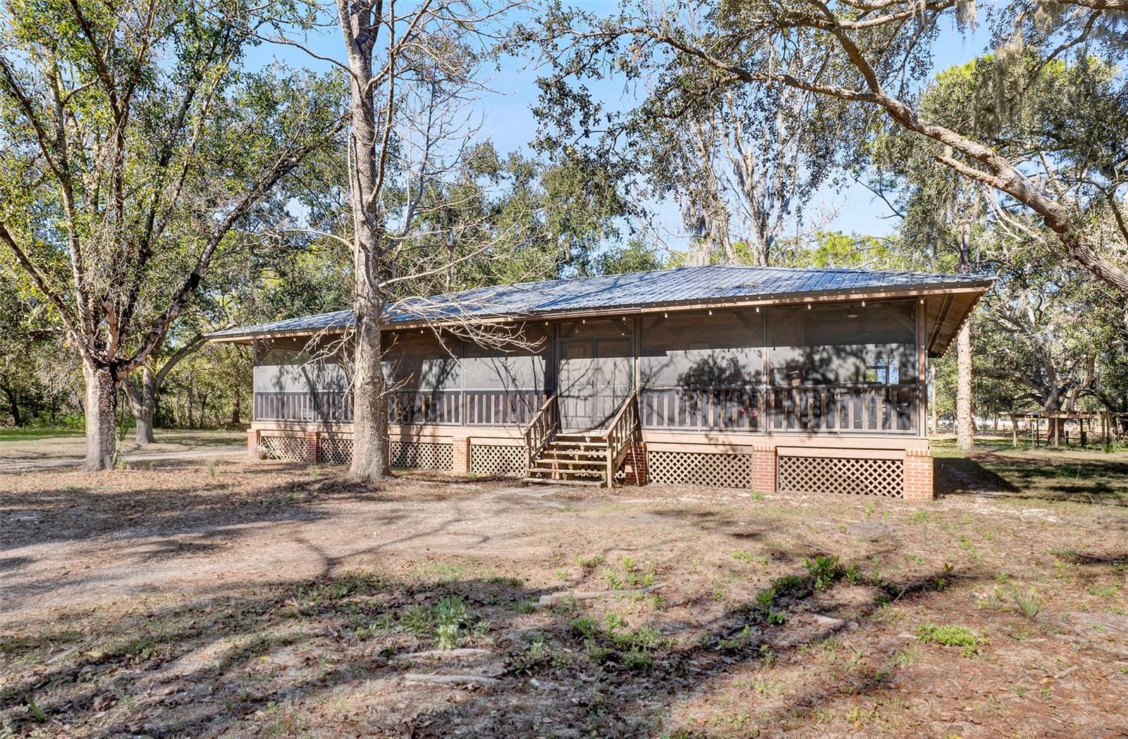 One or more photo(s) has been virtually staged. Welcome to a place where life slows down and space opens up. Set on 5 peaceful acres, this Sarasota farmette offers the rare freedom to live intentionally—no CDD fees, no restrictions on farm animals, and room to create your own homestead lifestyle.Begin your mornings on the wraparound porch, soaking in the quiet, open surroundings and natural beauty. Inside, the home blends modern comfort with farmhouse charm, featuring luxury vinyl plank flooring throughout and a custom accent entertainment wall that creates a warm, stylish focal point for gathering and relaxing. A water softening system adds everyday convenience and comfort.The property includes a main residence plus two detached garages, all with running electric and brand-new roofs installed in 2024—ideal for workshops, storage, equipment, or creative spaces that support a true farmette way of life.Outside, the land invites endless possibilities—gardens, animals, trails, or simply wide-open space to enjoy. Despite the serene setting, you’re a quick drive from Siesta Key’s world-famous beaches and University Town Center for premier shopping, dining, and entertainment, offering the perfect balance between country living and modern convenience.This is more than a home—it’s a lifestyle. A place to grow, gather, and live freely. If you’ve been dreaming of a Sarasota farmette where you can make the space truly your own, this property is ready to welcome you home.Please ask about our preferred lender incentives to help YOU save even more on this wonderful home.