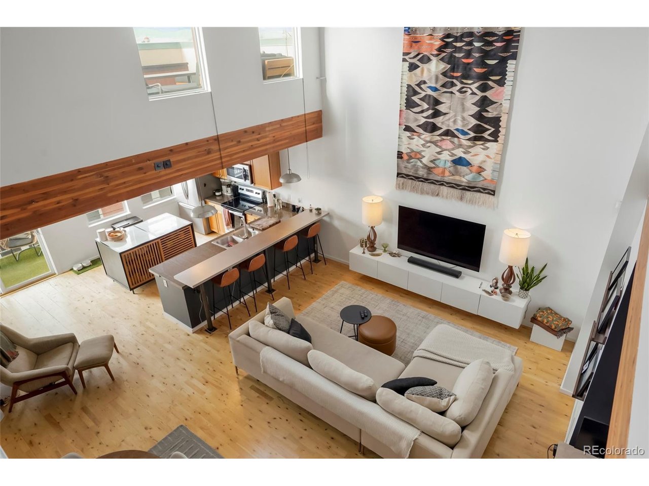 Want to be the envy of all your friends with a killer loft directly in the middle of Tennyson Street with a mountain-view rooftop? Today is your lucky day! Located in the heart of the Tennyson Art and Business District, the Lofts at Berkeley Park are some of the most sought after residences in Northern Denver. Kitty-corner to the historic Oriental Theater there's so much to do within 1 mile that there's not enough room to describe it all (see final picture for partial directory). The unit itself is a marvel of modern industrial design with a perfect union of exposed steel and wood architectural elements. Every portion of this open-concept home revolves around the cavernous 2-story great room, flanked by a renovated kitchen and flooded with natural light. Complimentary spaces on the main floor feel purpose-built and intentional: An office nook, a dining area, a pull-up bar - yet the entire space is fluid and customizable for any lifestyle. There's a full bath and a 2nd bedroom (non-conforming) as well as a laundry and utility closet with included stackable washer/dryer. The kitchen offers all the essentials and blends spaces with a cozy balcony for a grill or morning coffee and a dine-in peninsula for entertaining. The upstairs is an open-air owner's retreat with a spacious primary bedroom equipped with walk-in closet and remodeled en-suite bathroom. Nothing says urban living at it's finest like a catwalk to a private rooftop patio. It's really the star of the show with unobstructed views of the mountains and room for every activity (gardening, lounging, entertaining, etc). The building has secure, restricted access directly from Tennyson street as well as a secured parking garage around back with a dedicated parking AND storage space. While many developers have tried, none have replicated the trademark vibe of some of the original (and still the best) Tennyson Street lofts. If you want to live that Denver life you've always dreamed of - don't let this slip away!