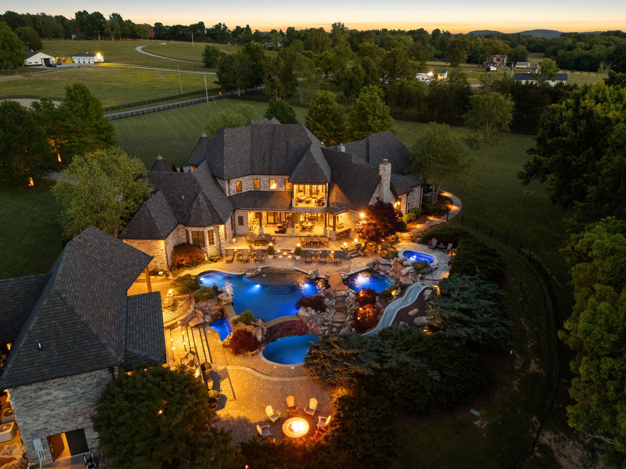 Seller is utilizing a structured “highest and best offer” process. All offers to be submitted by July 1st at 5pm. Seller reserves the right to accept an offer at any time prior to the deadline. Visit our company website for more information about how the process works and feel free to call the listing agents to set up your private tour. Property can be divided if less acreage is desired - - - - Set behind private gates on 62 acres of fully fenced woodland, riding trails, and manicured grounds, this 10,357 square foot estate represents the pinnacle of residential achievement. Soaring ceilings and breathtaking stonework set the tone upon arrival. A gourmet kitchen outfitted with a built-in steamer, deep fryer, and artisan pizza oven is complemented by two outdoor dining and grilling pavilions designed for effortless entertaining at any scale.Resort-caliber recreation awaits outside. A stunning pool and spa complex rivals the finest five-star retreats, alongside a dedicated 603 square foot pool house built for serious entertaining. Inside, a billiards room with its own guest apartment and private entrance offers guests complete autonomy. A game room, home theater, fitness room, and expansive third-floor bonus level ensure every passion is accommodated.A climate-controlled wine cellar sits at the basement level, accessible by private elevator. Whether you are hosting hundreds or unwinding alone, this home is built to deliver at every level.Eight acres of flat, fully fenced land surround the residence, while the remaining acreage opens into scenic wooded riding trails also fenced. The rear of the property offers rare, deep natural privacy. For the deserving buyer, this is the one of one you've been waiting for.