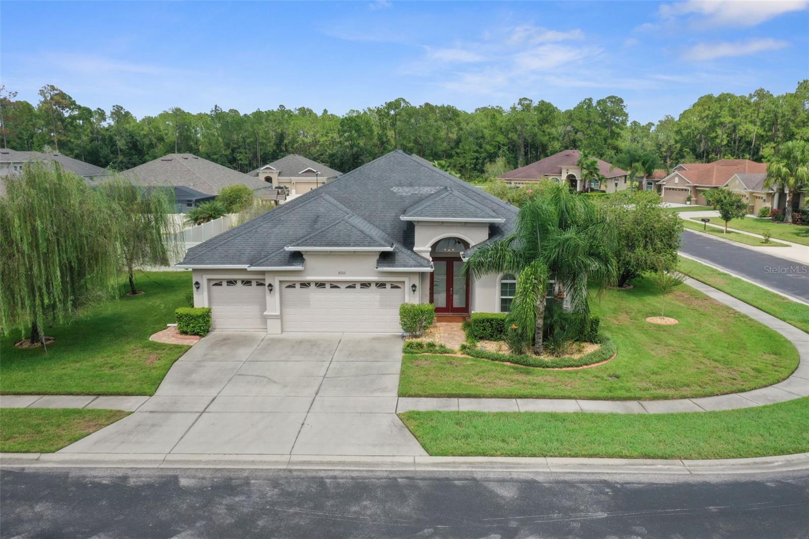 One or more photo(s) has been virtually staged. Welcome to Quail Woods, a gated Wesley Chapel community where elegance meets everyday comfort. This 4 bedroom, 3 bath home with a 3 car garage offers 2,657 sq ft of thoughtfully designed living space. Step through the covered entry into a foyer leading to formal dining and dedicated office space with newer flooring (2017). The heart of the home is a gourmet kitchen featuring rich wood cabinetry (2018), granite countertops, tile backsplash (2018), stainless steel appliances, large island, and an extended breakfast bar, perfect for entertaining. The kitchen opens to a spacious family room with triple sliders that seamlessly connect to the extended covered lanai (2018) for true Florida indoor, outdoor living.

The owner’s suite boasts newer flooring (2017), dual walk-in closets and a spa like bath with soaking tub, oversized walk in shower, dual vanities, and elegant tile finishes. Secondary bedrooms are split for privacy, including one with an pool bath. A generous laundry room with tub and storage adds convenience. Water heater 2025.

Built in 2015, the home is both energy efficient and modern. Set on nearly 1/3 acre, the property balances space and privacy. Low-fee Quail Woods offers nature trails, playground, and BBQ areas, not to mention TV and internet included, all just minutes from top schools, shopping, dining, and I-75.

This move in ready gem is the perfect blend of style, function, and location.