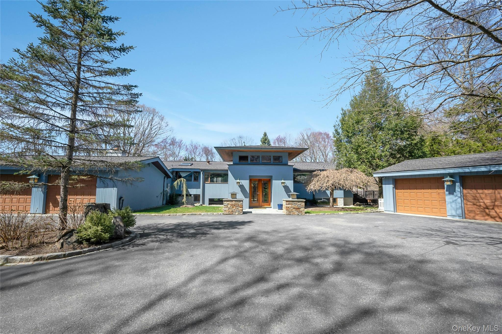 Experience true serenity in this stunning modern retreat in the woods of Pound Ridge. A dramatic entrance welcomes you into the home with vaulted cedar ceilings, Brazilian cherry floors, mahogany steps, and black cherry millwork. The free-flowing open floor plan connects skylit dining room, beautiful SieMatic custom kitchen, and two sunny living rooms, each with a wood burning fireplace. Main level primary suite offers spa-like bath and dressing room. Wrap-around Trex deck seamlessly connects the outdoors with the interior. The home features a heated in-ground pool, a hot tub, and two garages, one detached, that park four cars. Lovingly maintained by the current owners. Imagine yourself relaxing by the pool on over three private mostly-wooded acres. This is the lifestyle you've been waiting for.