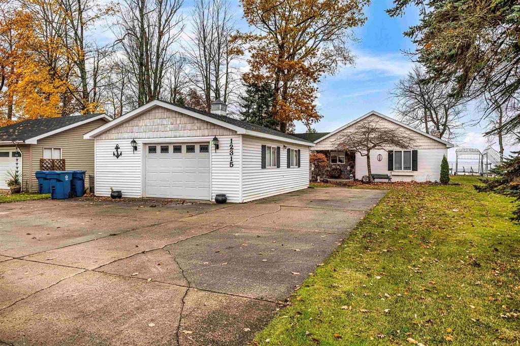 North Bay Waterfront Beauty on Houghton Lake!  Welcome to your lakefront dream! This stunning 4-bedroom, 2-bath home offers 2,124 sq ft of open-concept living with breathtaking views of Houghton Lake's North Bay. From the kitchen through the dining and living areas, a wall of sliding glass doors showcases the sparkling water, filling the home with natural light and endless lake views.  Step out onto the spacious deck-perfect for morning coffee, summer gatherings, or quiet evening sunsets. Just steps away, enjoy swimming, boating, and all your favorite water activities right from your own backyard.  The living room features a cozy stone fireplace and wet bar, ideal for entertaining year-round. A detached garage provides plenty of space for parking and storing your lake toys.  Whether you're looking for a year-round home, a weekend escape, or the perfect family retreat, this Houghton Lake treasure has it all!