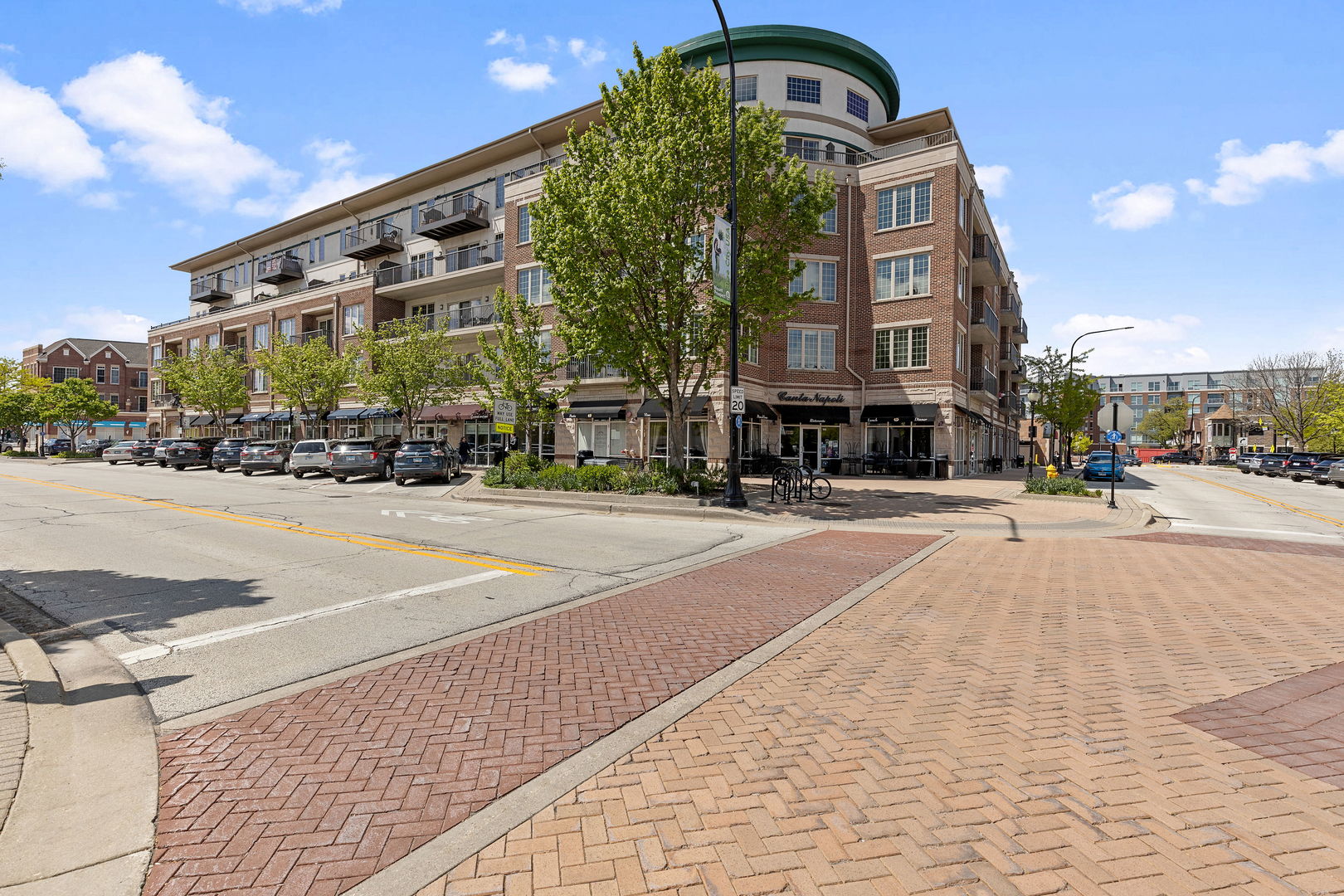 This approximately 1,149 square foot condominium features one bedroom , one bathroom and a spacious den which can be converted into a second bedroom. The vibrant neighborhood offers a walkable location, and the spacious building provides an abundance of natural light throughout the well-organized layout.  The expansive living space boasts engineered hardwood flooring and a neutral color palette, creating a warm and inviting atmosphere. This living room opens into a balcony with a view of the vibrant downtown area allowing you to enjoy the outdoors in comfort. The spacious kitchen is equipped with ample cherry cabinetry, stainless steel appliances, ceramic backsplash and granite countertop. It opens to the living room for ease of entertainment. The unit also boasts of a full size washer and dryer offering the convenience of a dedicated laundry area.  The primary bedroom is generously sized, providing the perfect retreat and a walk in closet. The spacious bathroom features tiled floor, ample corian vanity top, a garden tub and a spacious shower stall creating a spa-like oasis. The unit features one heated garage and the ability to create a second loft garage; a storage space is also provided. Located just steps from the Metra station, local boutiques, fine dining and library, this unit provides the luxurious lifestyle at an affordable price. Newer dryer, kitchen sink and hardware. Immaculately maintained.