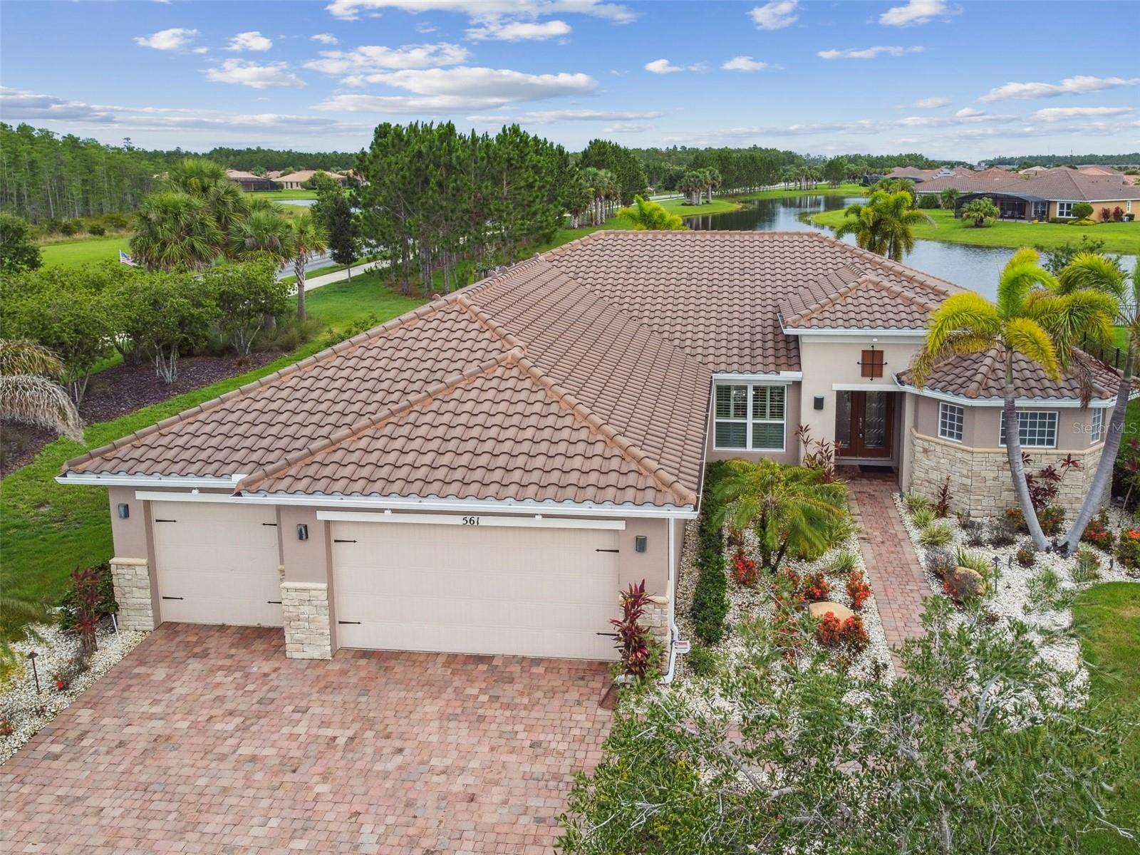 Waterfront elegance meets everyday comfort in this Aragon Estate model, perfectly positioned on an oversized corner lot in Solivita’s coveted Portofino enclave. A stone façade, lush custom landscaping, and double leaded-glass doors set an impressive tone that continues inside. Travertine-style plank tile, crown molding, and designer finishes flow through an open great room framed by postcard-worthy pond views.The chef’s kitchen is a showpiece—cook top, double wall ovens, walk-in pantry, wraparound breakfast bar, and a sunny nook overlooking the water. Entertain in style in the formal dining room under a dramatic double-tray ceiling. Your expanded primary suite indulges with a sitting area, tray ceiling, lanai access, and a spa-inspired bath featuring split vanities, a large walk-in shower, and dual custom closets. A light-filled den/study, two generous guest rooms, 2.5 baths, and a well-appointed laundry add flexibility. Out back, an extended screened lanai surveys the long pond and a yard deep enough for a future pool and pet-friendly fencing. An oversized 3-car garage completes this exceptional home, blending luxury, storage, and style in one unforgettable package. Key Highlights • 3 BR | 2.5 BA | Den | Extended 3-Car Garage • Oversized corner lot with panoramic water views • Travertine plank tile & crown molding throughout living areas • Gourmet kitchen: cook top, double ovens, walk-in pantry, breakfast bar • Expanded primary suite with lanai access & spa bath • Covered, extended screened lanai overlooking pond • Yard sized for pool addition & fenced pet friendly area • Whole house wired security and sound system. Located in Portofino at Solivita—resort-style 55+ living with world-class amenities. This home was lived in only 6 months each year! Solivita is known for its vibrant 55+ community, offering an abundance of activities and amenities for active adults. Whether you’re enjoying a round of golf, engaging in fitness classes, or simply strolling along scenic walking paths, this neighborhood promotes an active and fulfilling lifestyle with over 200 clubs, sports, and activities. Enjoy the community’s clubhouse, softball field, 14 swimming pools, an indoor walking track, and much more. Every day offers something new to explore and enjoy! This home also features easy access to nearby shops, dining, and health care, offering the perfect balance of convenience and privacy. Whether you’re relaxing at home or exploring the vibrant community, this home offers the perfect balance of privacy and lifestyle.