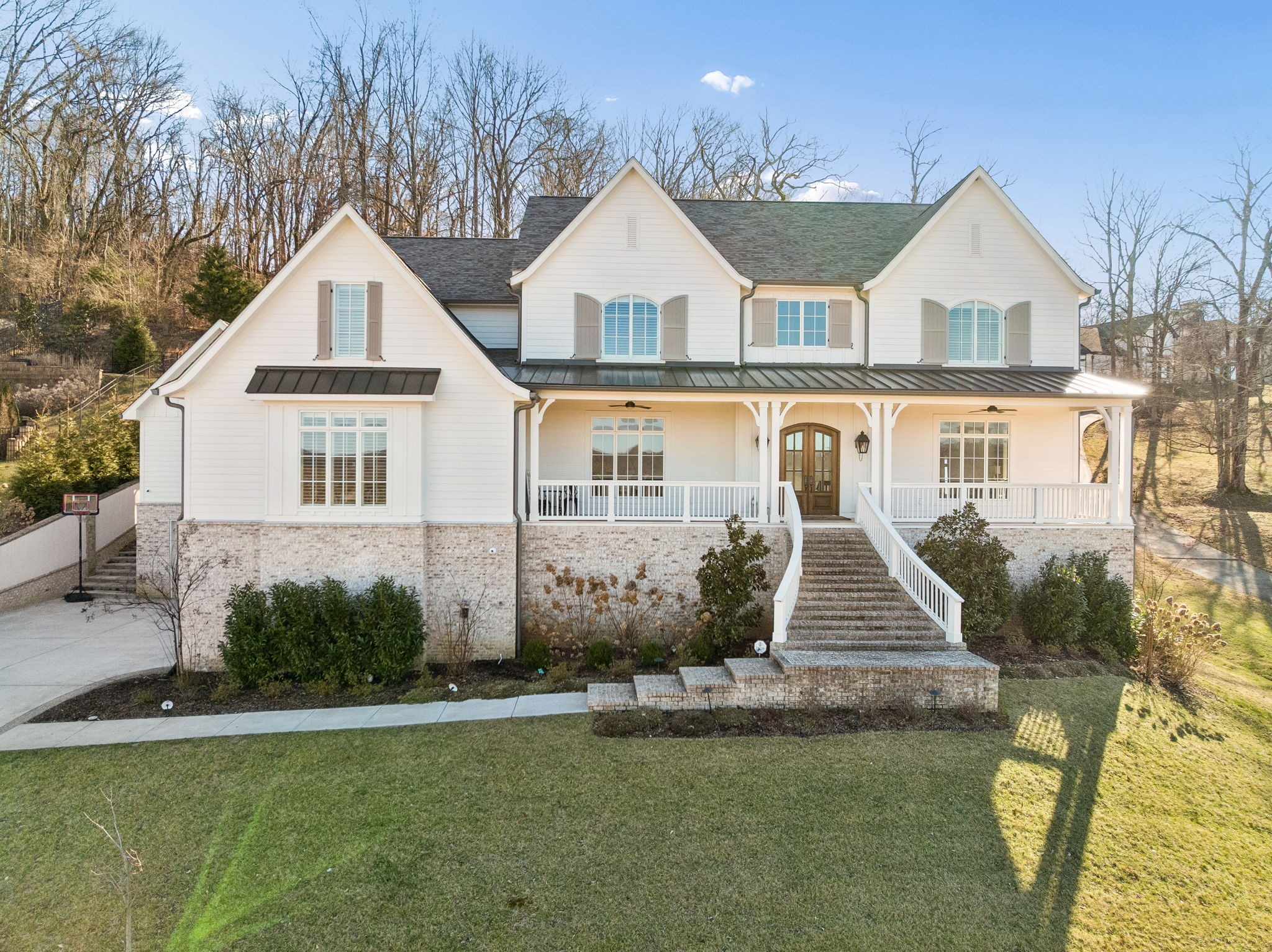 This luxurious custom residence in the exclusive gated community of Stockett Creek is ideally located just minutes from the Warner Parks, Franklin, Brentwood, Green Hills, & only 20 minutes to downtown Nashville. Offering the perfect balance of privacy, sophistication, & everyday livability, the home is beautifully landscaped with sweeping front porch views and a serene, private backyard—truly the best of both worlds with Williamson County schools & effortless city access.Thoughtfully designed across three levels, the home features an elevator, finished basement with second kitchen, warm natural light, spacious rooms, hardwood floors, two fireplaces, a private office, & a main-level primary suite with spa bath. A second ensuite bedroom with vaulted ceiling is also on the main floor. The covered patio with fireplace creates an ideal setting for entertaining or quiet evenings enjoying Tennessee sunsets. The gourmet kitchen is exceptionally appointed with high-end appliances, quartzite counters, paneled cabinetry, glass-front accents, gas cooktop with griddle, warming drawer, hidden beverage drawers, pot filler, farmhouse sink, walk-in pantry with dumbwaiter access from the basement garage, & a large island with seating for five. It opens seamlessly to the family room and includes a built-in office nook & mudroom access.The primary suite offers private patio access, double vanities, soaking tub, walk-in shower, & a custom closet with stackable washer/dryer. Upstairs features a spacious laundry room, three ensuite bedrooms, & a bonus room. The basement offers exceptional versatility with a home gym, full bath, art studio, game/living room, second kitchen, storage, & access to both garages. High ceilings, refined finishes, & custom craftsmanship define this move-in-ready showplace.  Zoned for Grassland Elementary, Grassland Middle, & Franklin High, & convenient to CPA and Ensworth this is a rare opportunity in one of Williamson County’s most coveted gated communities.