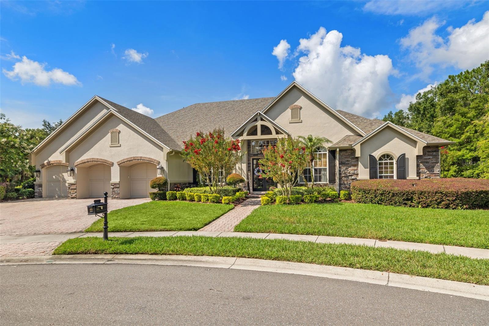 Under contract-accepting backup offers. This distinctive one-story pool home is nestled on nearly an acre at the end of a cul-de-sac in the gated enclave of Whitehall in Tampa Palms. This stunning home offers 4 bedrooms, a designated office, 3 1/2 baths, and an incredible lanai with an outdoor kitchen, resort-style pool, and generous backyard. Step through the French-style double glass doors into a welcoming open layout with 12-foot ceilings, impressive crown molding, and rich pine hardwood floors. The home features thoughtfully designed living spaces including a formal dining area and a spacious family room outfitted with ceiling-mounted speakers throughout. The stunning kitchen, with coffered ceiling accents, is built for serious cooking and entertaining. It boasts a large center island with a prep sink, Sub-Zero refrigerator, gas cooktop, warming drawer, built-in double ovens, microwave, two dishwashers, farmhouse sink, and a huge walk-in pantry. The primary suite is a peaceful retreat with French doors leading to the lanai and pool, custom-built closets, and a spa-inspired bath featuring dual vanities, a soaking tub, and a walk-in shower with dual showerheads. The split-bedroom floorplan offers enhanced privacy and flexibility. Two of the bedrooms are tucked beyond a private hallway, where they share a spacious Jack and Jill bathroom and an adjoining study area ideal for homework or remote work. The fourth bedroom is located near the rear of the home with privacy doors and a dedicated bath. Across the back of the home, French doors and pocket sliders open to a backyard built for year-round enjoyment. The PebbleTec pool with waterfall feature is surrounded by two distinct outdoor living areas—perfect for relaxing or gathering with friends. The outdoor kitchen, updated in 2022, includes a premium Evo hibachi grill, beverage fridge, stainless sink, beautiful hood, built-in grill, and a gas fireplace, all under a tongue-and-groove ceiling with brick pavers. Whitehall residents also enjoy access to three pools, tennis courts, a fitness center, and a playground, ensuring there's something for everyone to enjoy. Conveniently located near I-75, USF, Advent Hospital, Moffitt Cancer Center, Flatwoods running/biking trails, neighborhood schools, and an array of shopping and dining options.