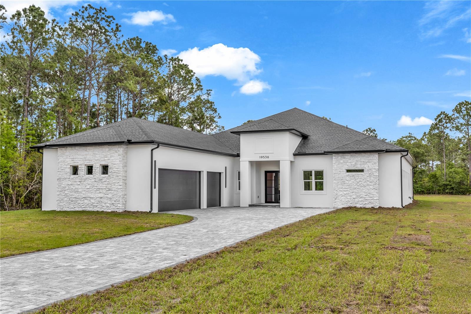 One or more photo(s) has been virtually staged. WOW does not even begin to cover it. BRAND NEW CONSTRUCTION sitting on 1.03 DRY ACRES in the sought-after Wedgefield community, packed with jaw-dropping finishes you have to pinch yourself to believe. This is not your average new build. This is magazine-worthy living at its absolute finest. From the moment you pull up, that ELEVATED DOUBLE FRONT DOOR WITH GLASS makes a statement. Step inside and you will immediately notice the SOARING HIGH CEILINGS, LVP FLOORING THROUGHOUT, and ENERGY-EFFICIENT PGT HURRICANE IMPACT WINDOWS.... this home was built to impress from the inside out. Oh, and did we mention the 3-CAR GARAGE? Now let's talk about that KITCHEN. TALL CEILINGS WITH STUNNING FAUX WOOD BEAMS, jaw-dropping FORNO BLACK APPLIANCES, OVEN-MICROWAVE COMBO, STACKED CABINETRY, THICK-SLAB QUARTZ ISLAND, and a WALK-IN PANTRY. This kitchen does not just cook....it performs. The FORMAL DINING ROOM flows right into a spacious living area that opens through SLIDING GLASS DOORS onto a COVERED PATIO WITH WOOD CEILING FEATURE and an EXPANSIVE DECORATIVE PAVER PATIO. You are going to live outside on this patio. Every bathroom in this home features FLOOR-TO-CEILING DECORATIVE LUXURY TILE. The master suite is pure pinch-yourself luxury with HIS AND HER WALK-IN CLOSETS, a FREESTANDING SOAKING TUB, DOUBLE VANITY, LINEN CLOSET, and a WALK-IN SHOWER that belongs in a five-star resort. The JACK-AND-JILL BATH is the perfect space and one bedroom has its own PRIVATE EN-SUITE WITH DIRECT PATIO ACCESS. A DOUBLE-DOOR OFFICE/BONUS ROOM rounds it all out. Additional highlights include CUSTOM BUILT-IN CLOSETS in every secondary bedroom, a fully appointed INDOOR LAUNDRY ROOM with washer, dryer, wash tub, countertop and cabinets, and HIGH CEILINGS throughout every single room. Wedgefield puts you 20 minutes to Orlando International Airport, 30 minutes to downtown Orlando, and 40 minutes to the Space Coast — peaceful acreage living with unbeatable access to all Central Florida has to offer. No detail was missed. No corner was cut. BRAND NEW CONSTRUCTION. MOVE-IN READY. Come see it before someone else pinches themselves on YOUR dream home.