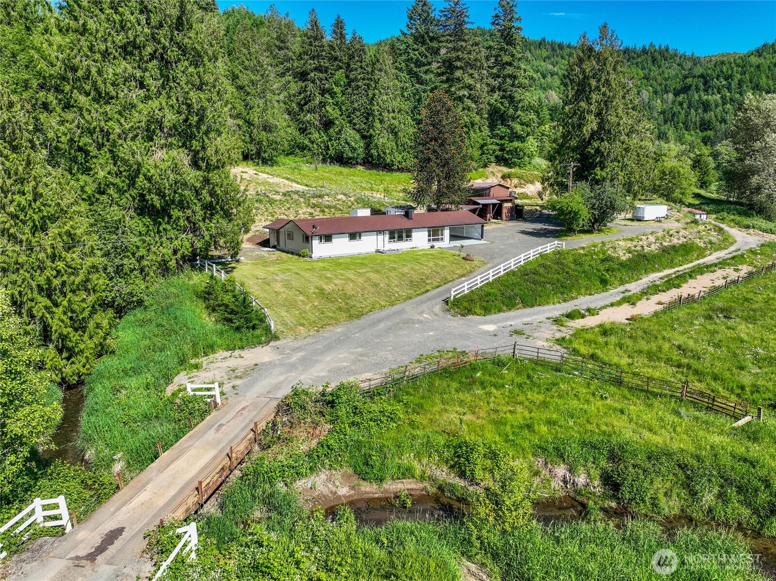 Nestled among rolling pastures, mature timber, and newly planted Douglas Fir, this 20+ acre legacy property offers the perfect blend of country living, recreation, and self-sufficiency. Wander the network of trails on foot, horseback, or ATV, then cool off in the in-ground pool or relax along the year-round creek that meanders through the property, creating shady retreats for entertaining and outdoor enjoyment. The ground feature fenced pastures, apple and cherry trees, a stable, large chicken coop, shop, and additional covered parking for equipment, hobbies, or farm use. The charming Lindal Cedar Home is designed for flexibility and comfort, featuring a sitting room off the primary suite ideal for a home office, reading nook, or hobby space, plus a bonus room on the opposite side of the home. Though the home has had upgrades, the original charm has been left to enjoy, including slate and hardwood flooring, a wood stove for additional heat and exposed beams in the living room. Whether you're seeking a hobby farm, equestrian property, recreational retreat, or multigenerational homestead, this exceptional acreage offers room to grow, explore, and create lasting memories. Also, to note, is that the land can be divided into 10-acre parcels, giving the opportunity to split and sell or to develop further. RV Pad has power and so does the field across the driveway for easy hotwire hookup. Take your time to walk this property, it is well worth it!