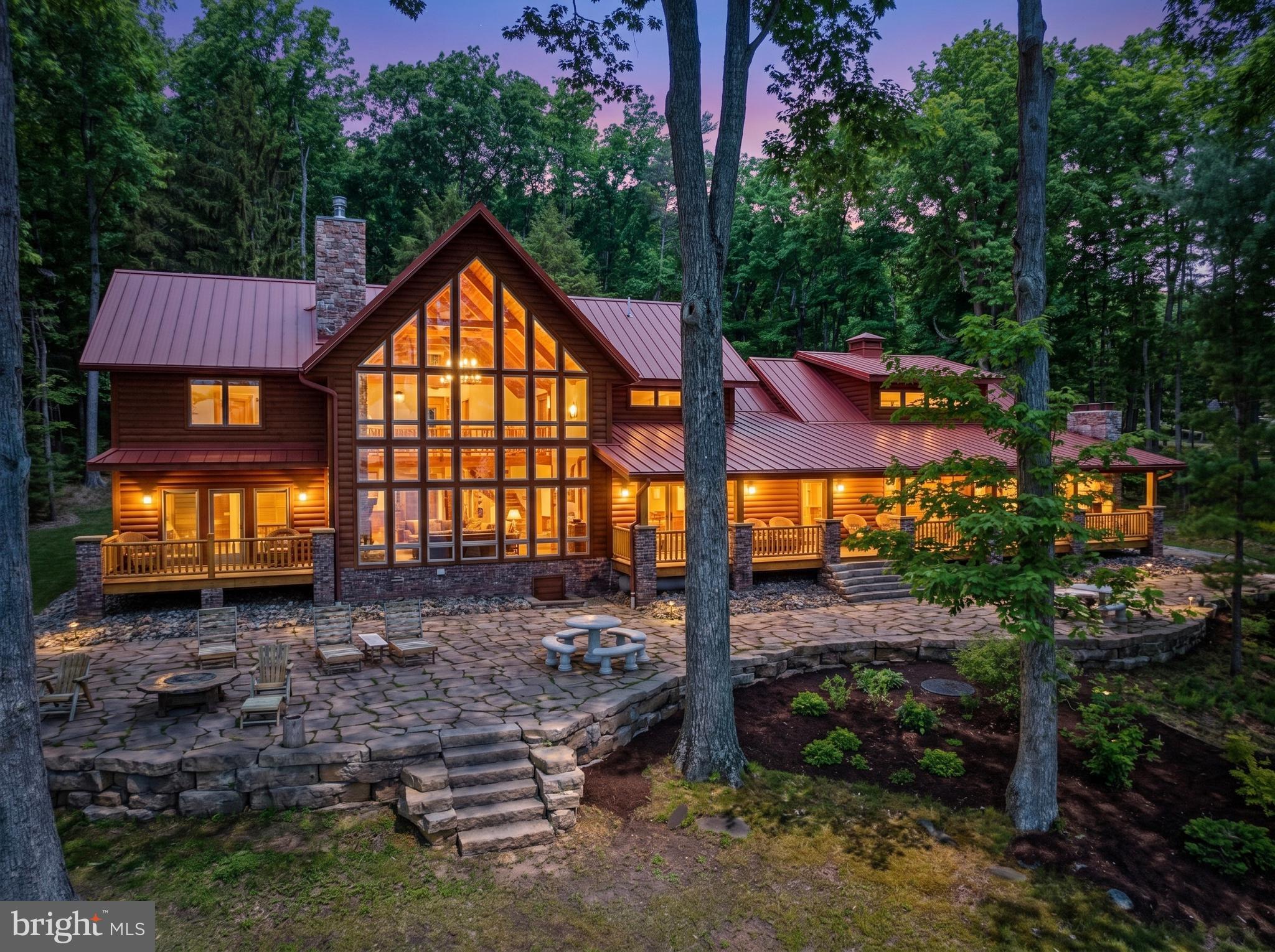 Stunning lakefront log home offering the perfect blend of rustic elegance and modern comfort. Boasting 181 feet of pristine waterfront, this 4-bedroom retreat features four en suite bedrooms. Three of the suites have their own fireplace that creates a warm, cozy ambiance throughout. The abundance of windows allows you to enjoy the beauty of the outside during any season from every level of this wonderful home. The open floorplan and upgraded kitchen feature an island and Corian countertops, providing ideal space to enjoy with family and friends. Enjoy breathtaking lake views from the expansive, covered outdoor deck, which also offers an outdoor fireplace—ideal for relaxing or entertaining year-round. The firepit and type A dock are just steps away and provide even more enjoyment. The central location on a dead-end road is unmatched, as are the gorgeous sunrises! This is a rare opportunity to own a private waterfront escape with exceptional charm and character.