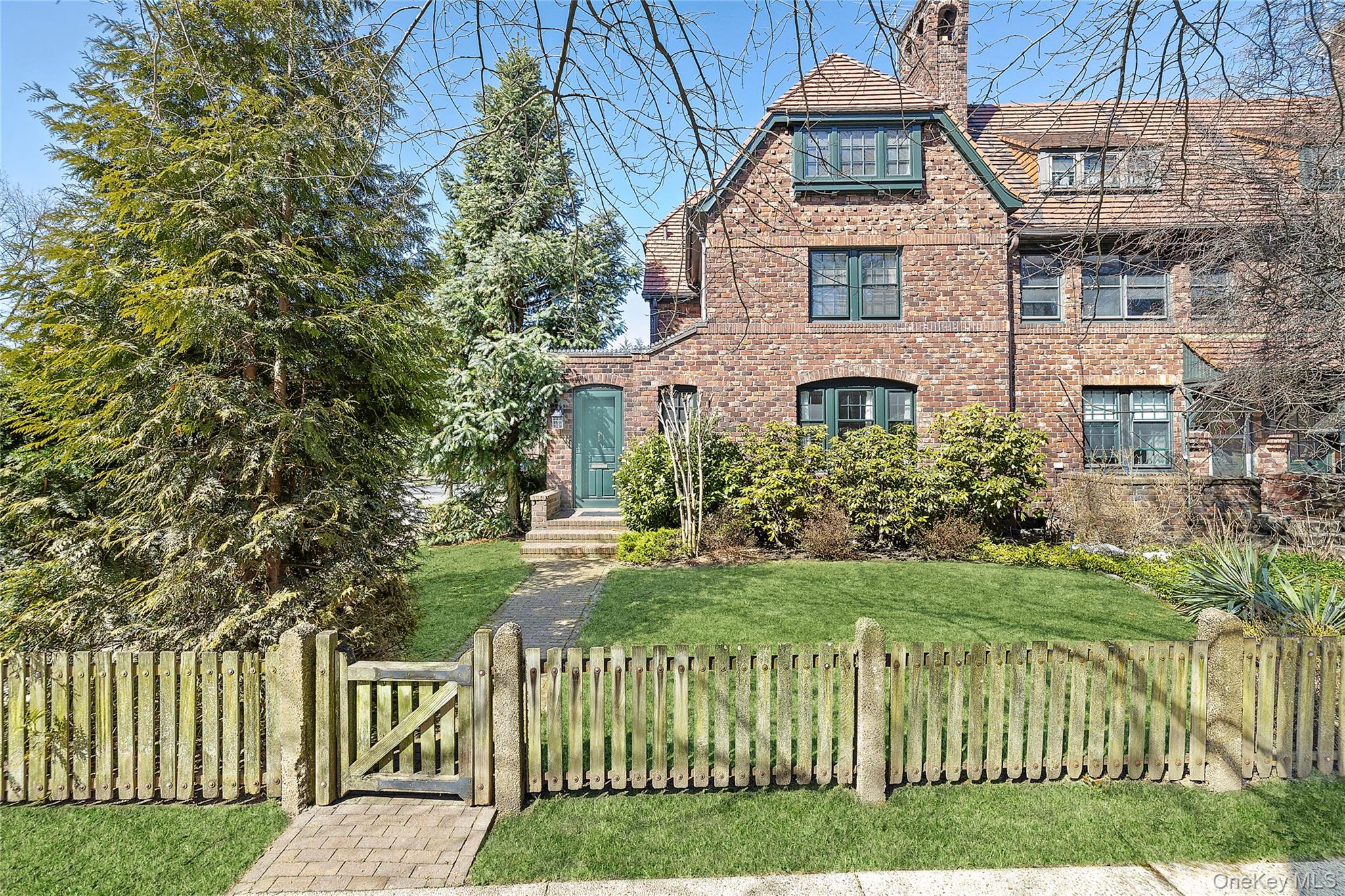 Rarely available, this beautifully renovated semi-attached tapestry brick townhouse exemplifies the timeless elegance and craftsmanship that define Forest Hills Gardens, seamlessly blending historic character with sophisticated modern updates.A charming entry sunroom with terracotta clay tiles welcomes you into the home, setting a warm and inviting tone. The gracious living room, anchored by a built-in gas fireplace, offers a refined space for both intimate evenings and lively entertaining, complemented by a tastefully appointed powder room discreetly located for guests. The newly renovated open kitchen is a chef’s dream, featuring custom cabinetry, a custom walnut built-in dining room sideboard with bespoke hardware, Silestone countertops, and premium stainless steel appliances, including a Sub-Zero refrigerator, Bosch dishwasher, Waterstone faucet, and Fulgor Milano oven with warming drawer. A door just off the kitchen opens to an expansive deck above the garage, providing an elegant setting for al fresco dining, morning coffee, or relaxed outdoor entertaining.The second floor offers two generously proportioned bedrooms, including a serene primary bedroom featuring a second gas fireplace and abundant windows that fill the space with natural light. The beautifully renovated marble hall bath showcases herringbone marble tile flooring and a large glass-enclosed shower, creating a spa-like retreat.The third floor features two additional bedrooms and a luxurious full bath with marble tile, an oversized glass-enclosed shower, and a deep soaking tub, combining elegance and comfort for guests, private retreats, or flexible living space.The fully finished basement offers expansive and versatile living space, including a recreation room, guest room, full bath, and a mudroom area with a large farm sink and cabinetry. The basement also provides generous storage and flexible areas that can serve as a home gym, office, or hobby space.Additional highlights include central air and heat, a detached garage, private driveway, and expansive front and side gardens with mature plantings.Located on one of the prettiest streets in Forest Hills Gardens, this exceptional residence is surrounded by the neighborhood’s signature tree-lined streets, distinctive architecture, and storied charm. Residents enjoy the convenience of a quick commute to Manhattan via the LIRR or subway, while Austin Street’s boutiques, cafés, and restaurants are just moments away. The historic West Side Tennis Club and the beloved Forest Hills Stadium add to the neighborhood’s cultural vibrancy, making Forest Hills Gardens one of New York City’s most coveted and enchanting communities.