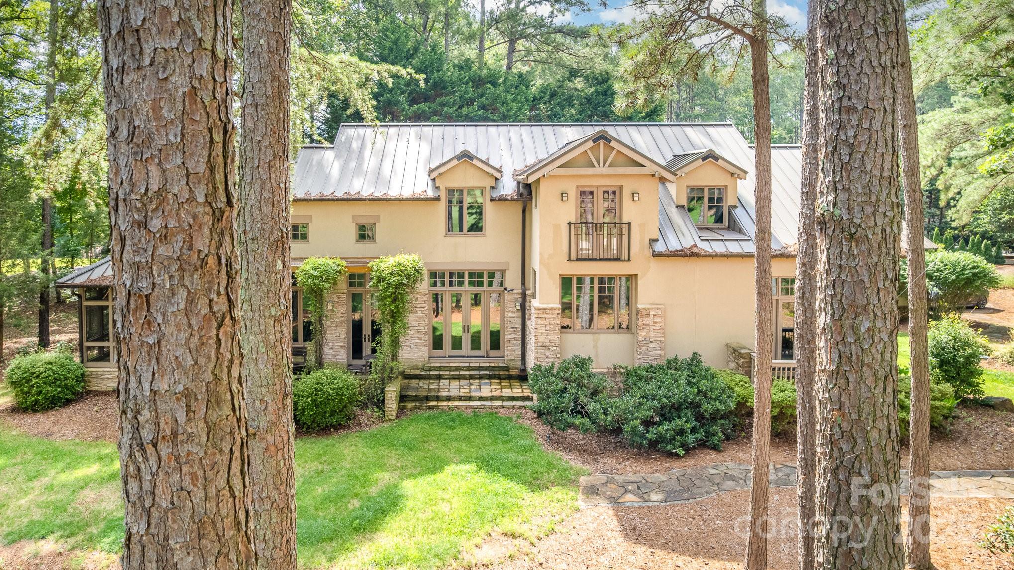 Welcome to the pinnacle of refined Southern Living on Badin Lake!! Nestled on the 11th green of the award winning Tom Fazio designed golf course, this custom home features 100 year old reclaimed wooden floors, vaulted ceilings with wooden beams and wood work throughout with custom built-in shelving and a chef worthy kitchen with gorgeous limestone countertops and private master and office space downstairs. Upstairs you'll find 3 spacious bedrooms, 2 bathrooms and flex space. Enjoy peaceful and private views on your screened in porch.